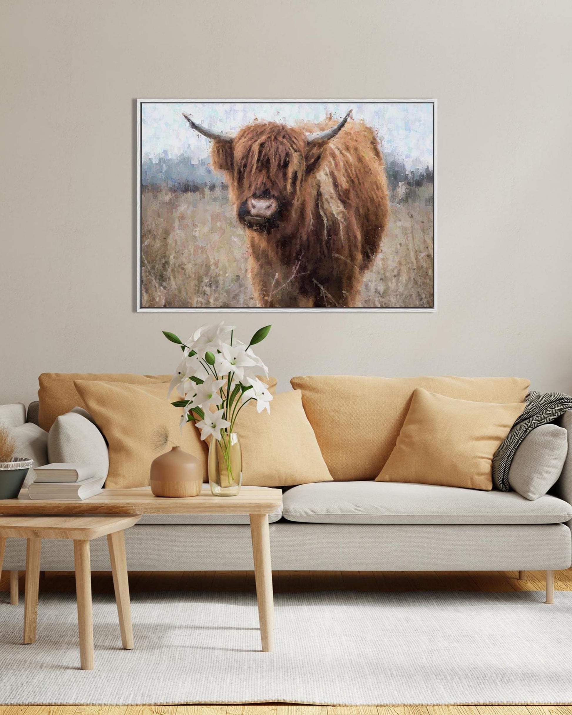 Living room with a beige sofa, wooden coffee table, and a framed picture of a Highland cow on the wall.