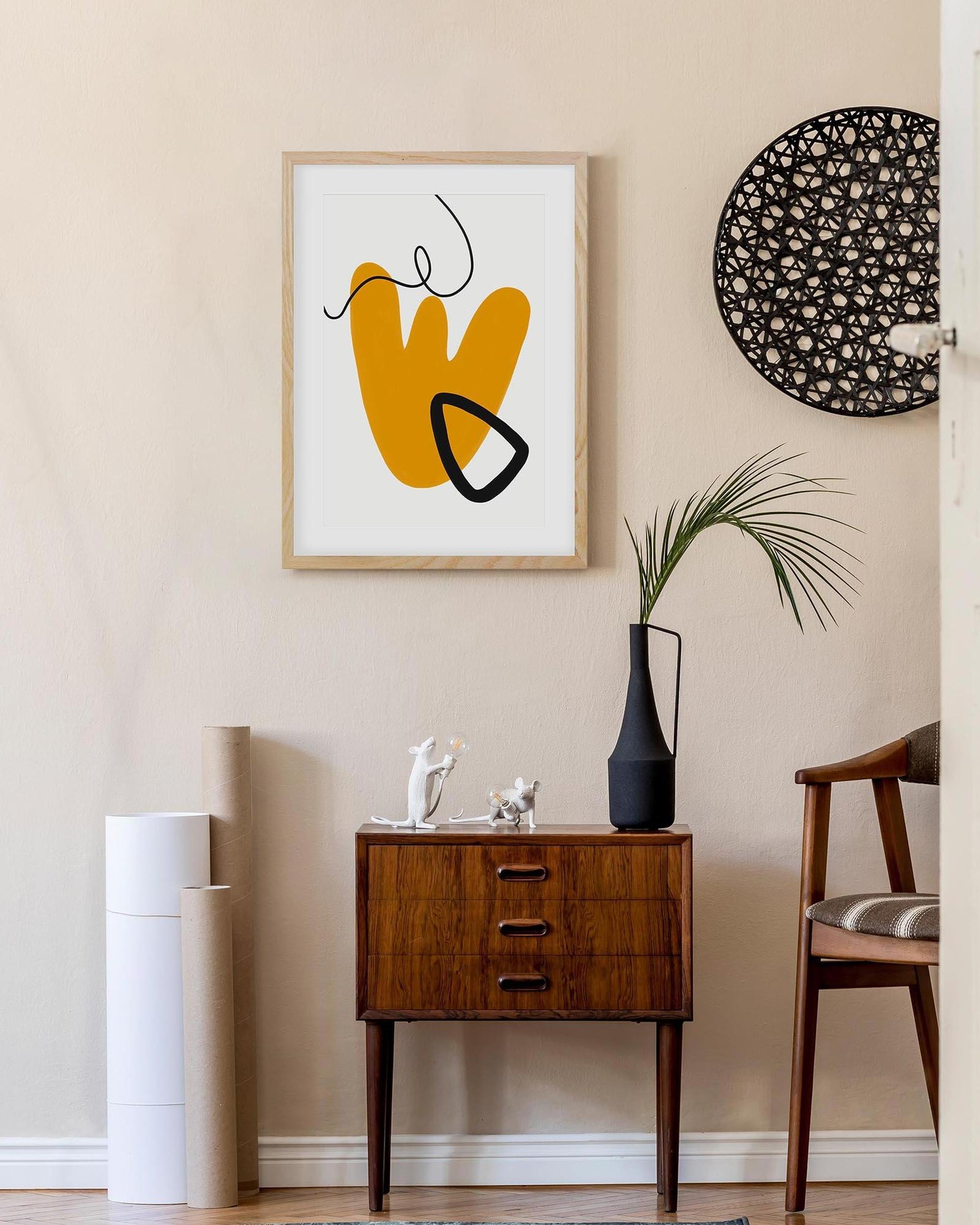 Modern interior with abstract art, wooden cabinet, and decorative items.