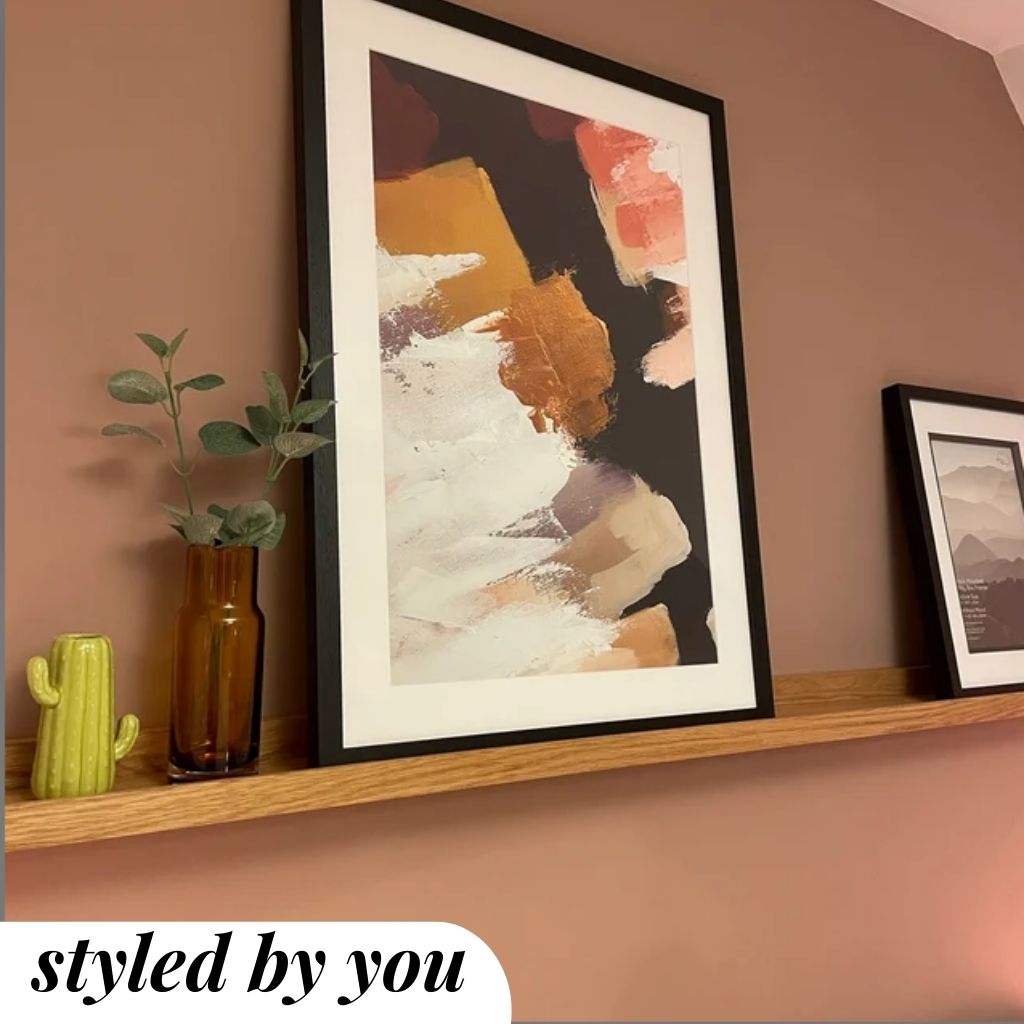 framed prints on a shelf 