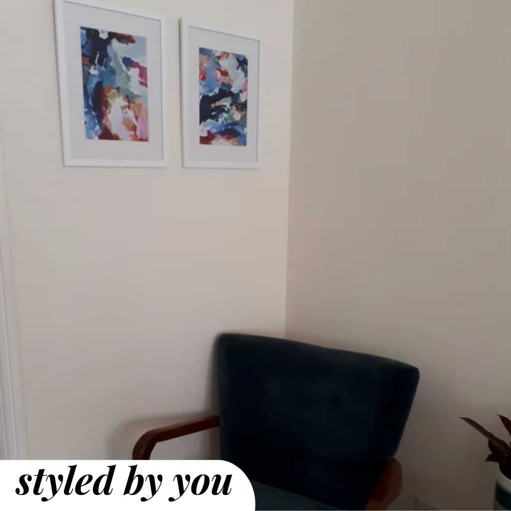 framed prints above a chair