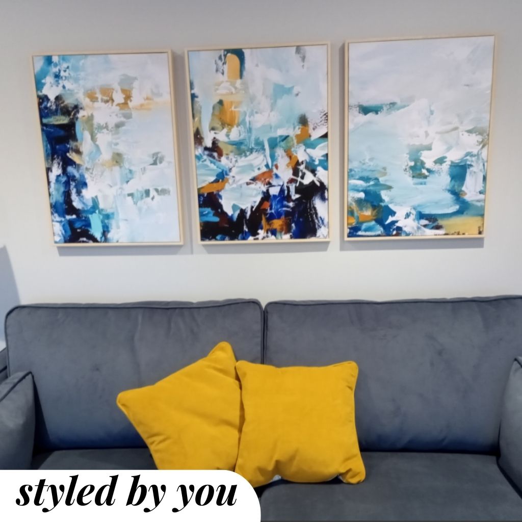 framed canvas prints above the sofa