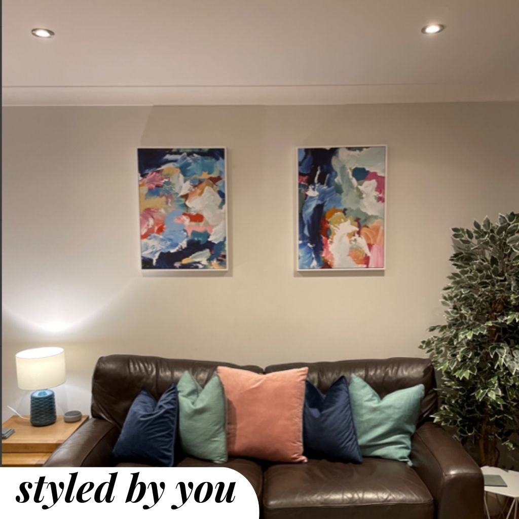 framed canvas prints above a sofa