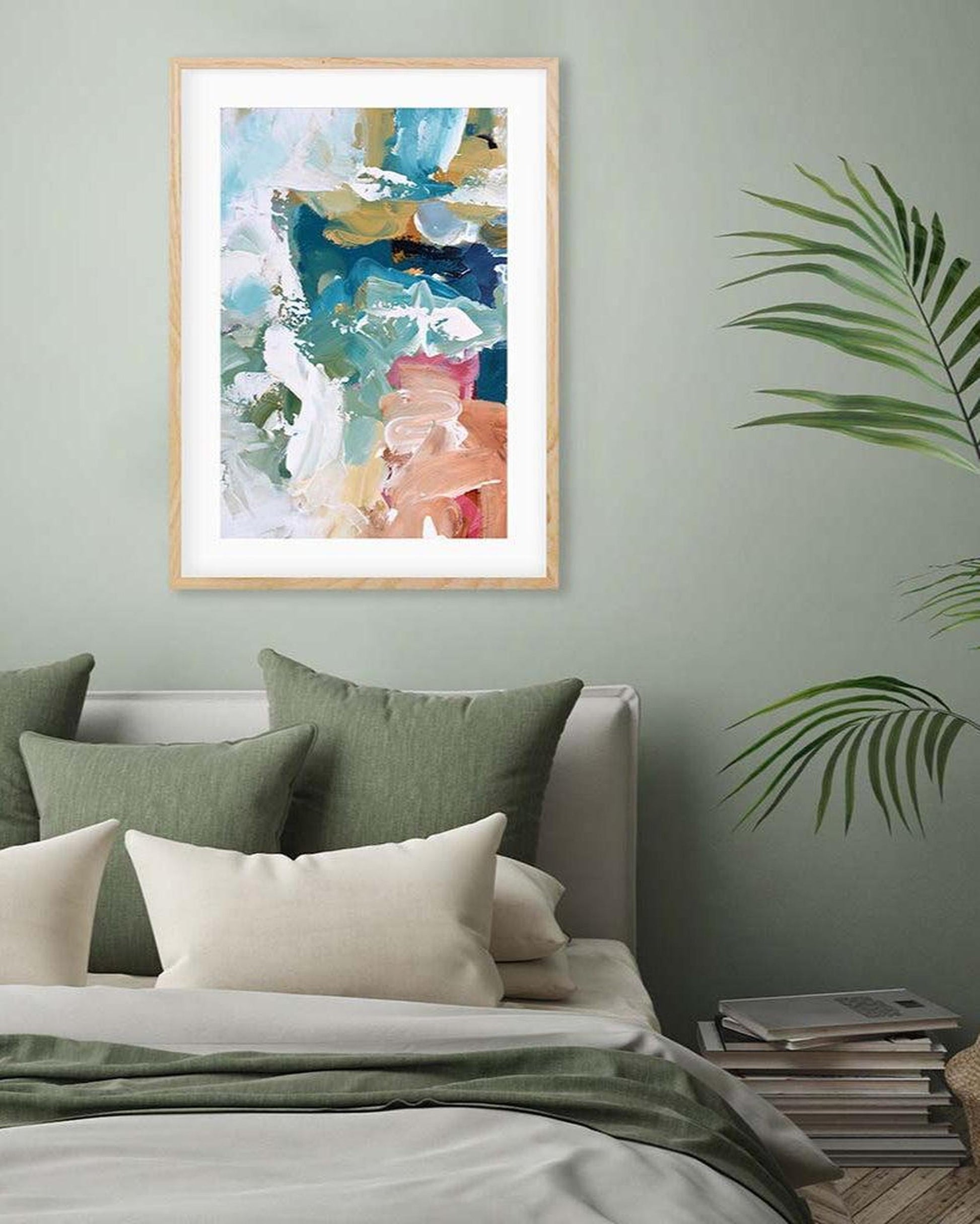 Abstract art print on a wall above a bed with green pillows