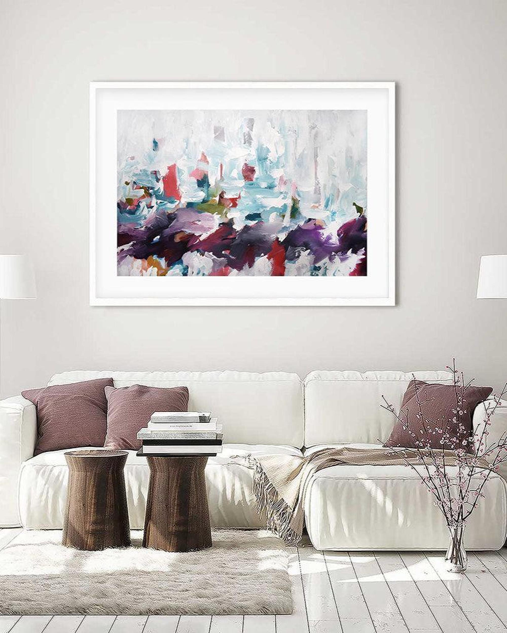 Living room with a white sofa, decorative pillows, and a colorful abstract painting on the wall.