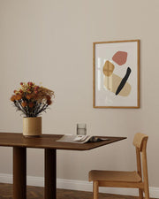 Dining room with wooden table, chair, and abstract art on the wall.