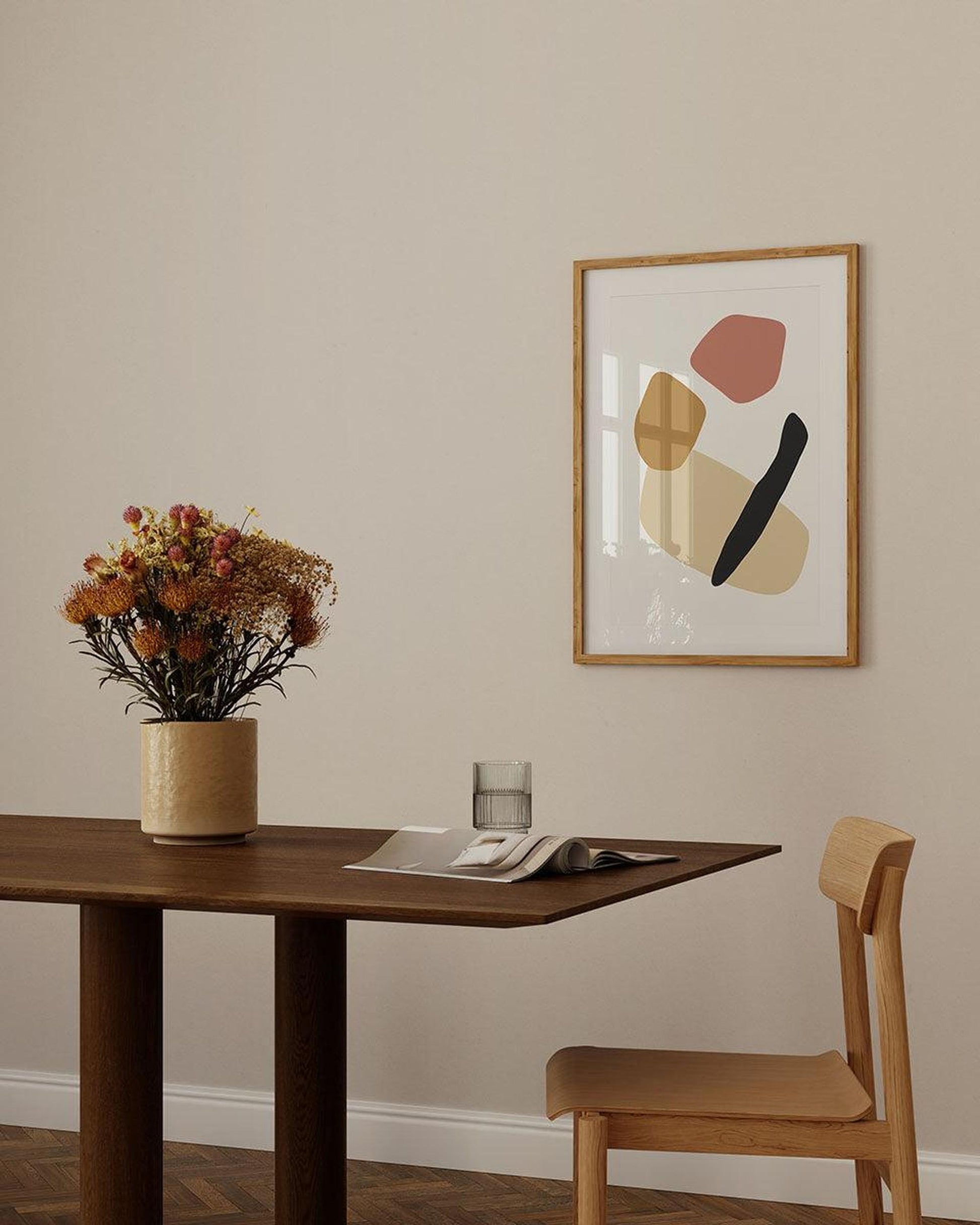 Dining room with wooden table, chair, and abstract art on the wall.