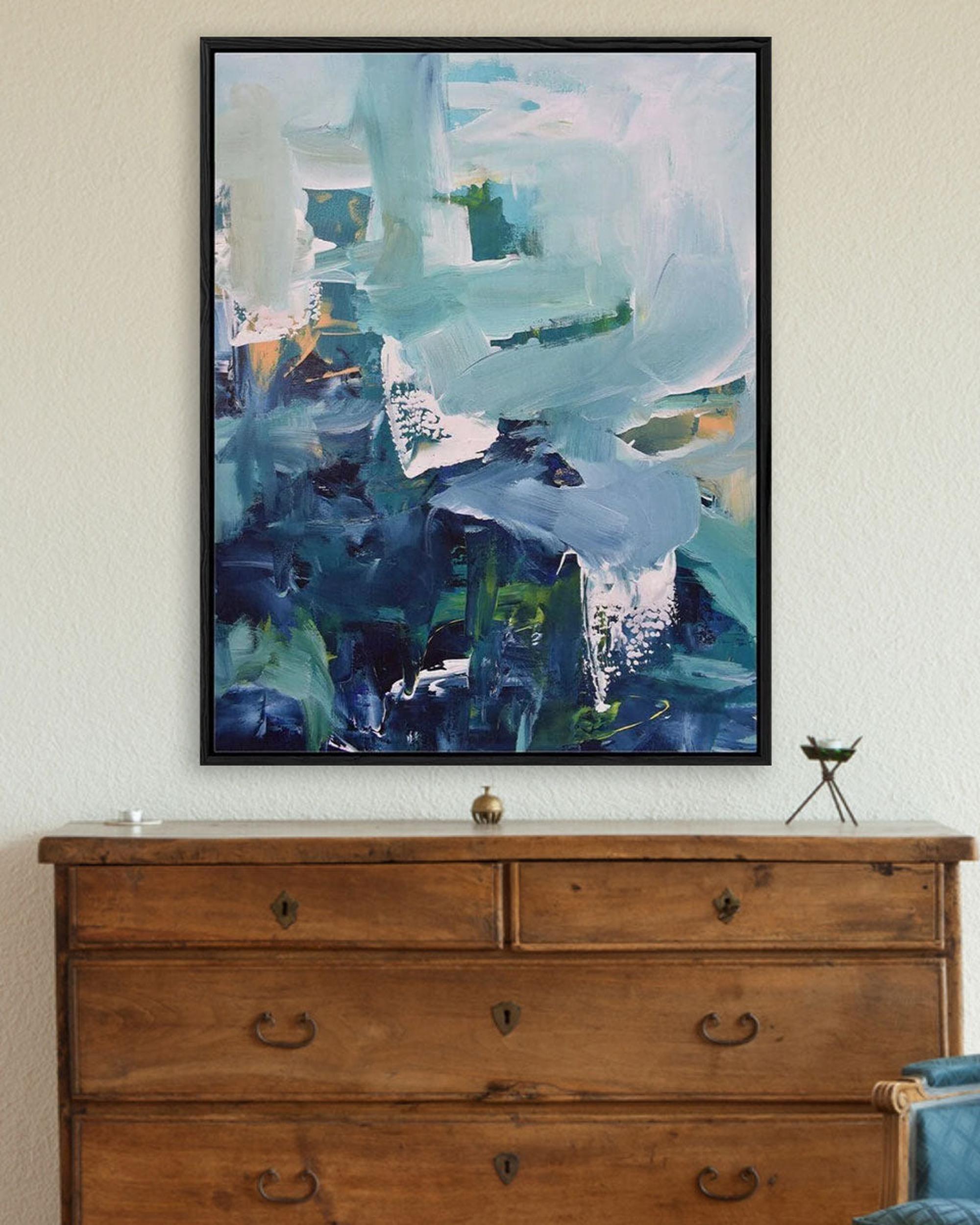 Abstract painting on a wall above a wooden dresser