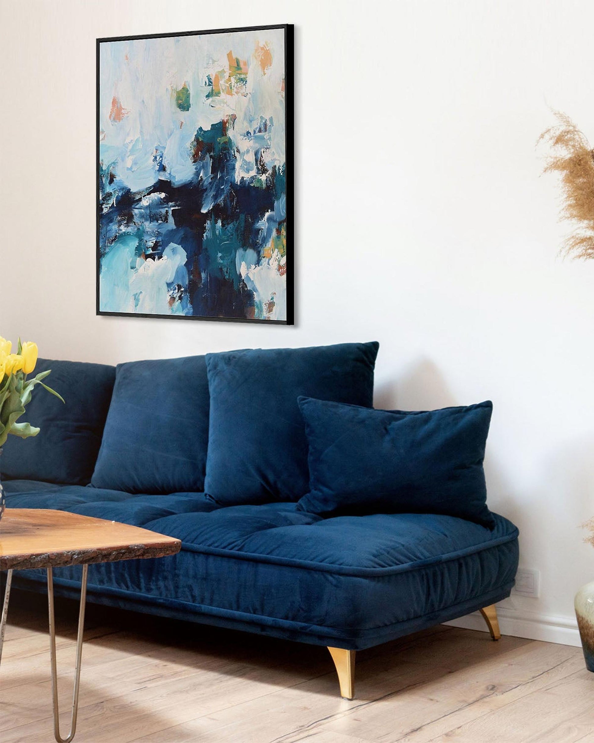 Blue sofa in a living room with abstract art on the wall