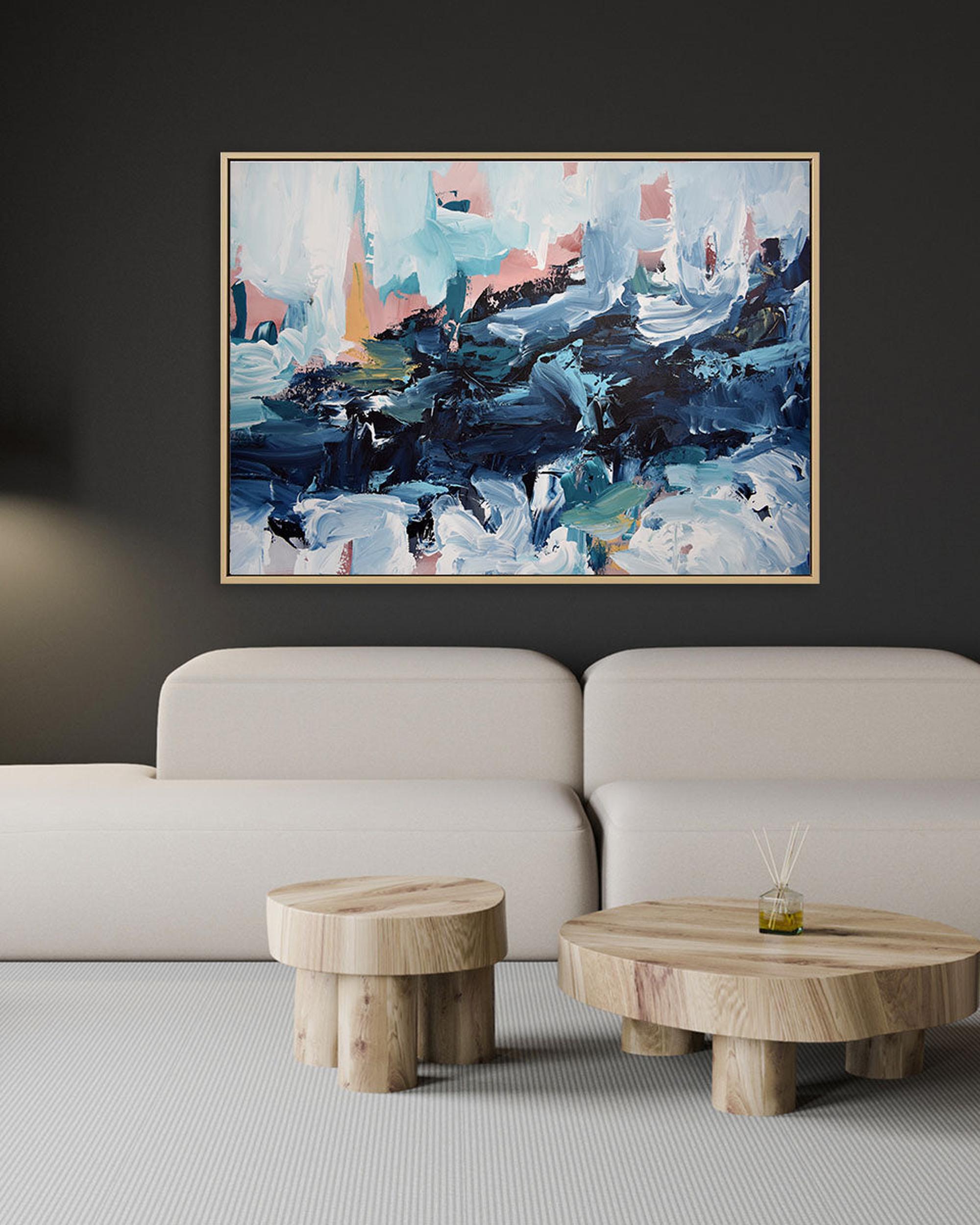 Abstract painting on a wall above a sofa with wooden side tables.