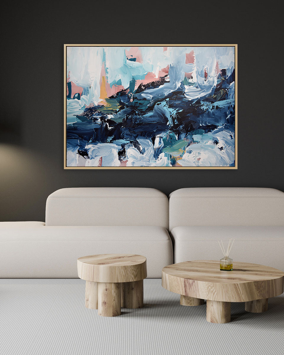 Abstract painting on a wall above a sofa with wooden side tables.
