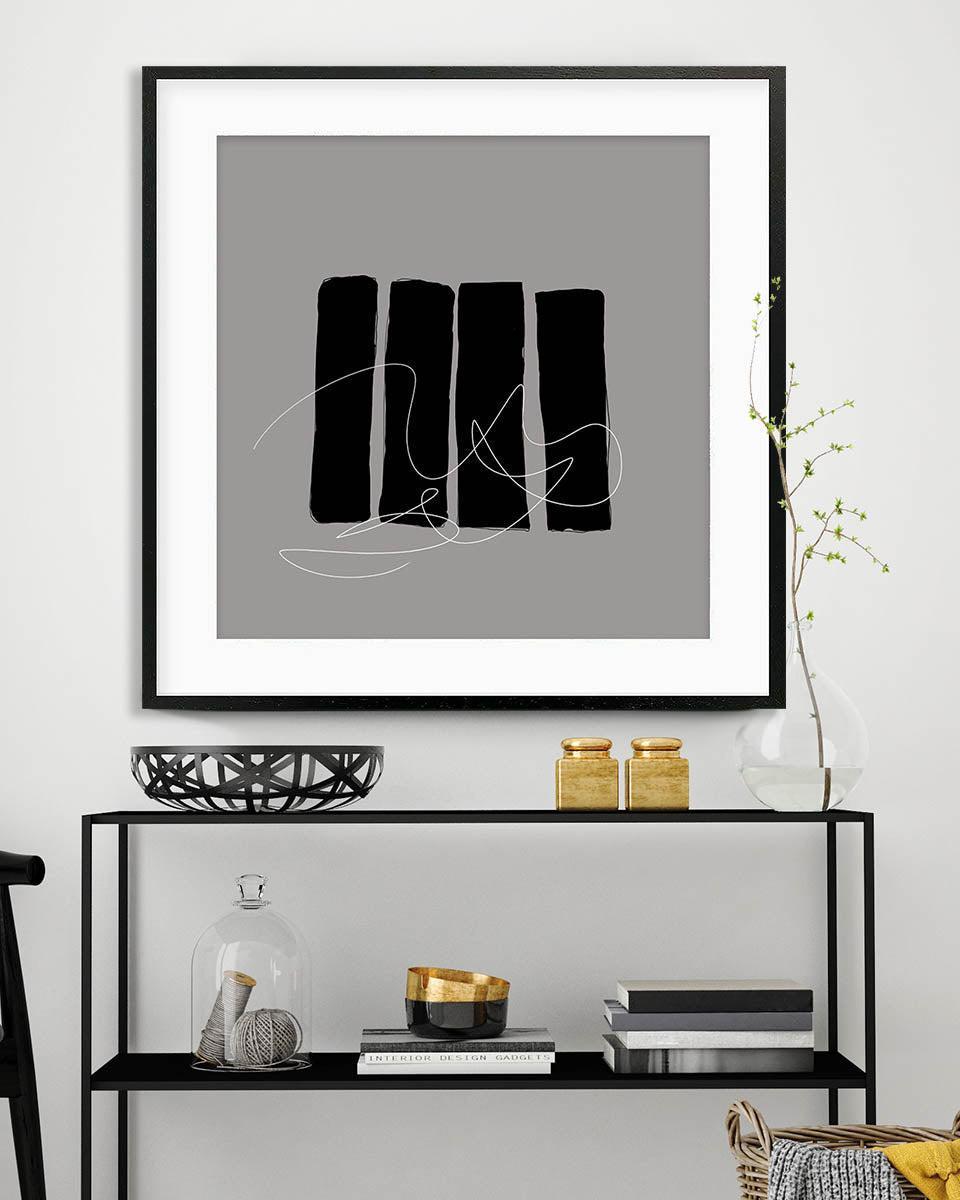 Framed abstract art piece on a wall above a console table with decorative items.