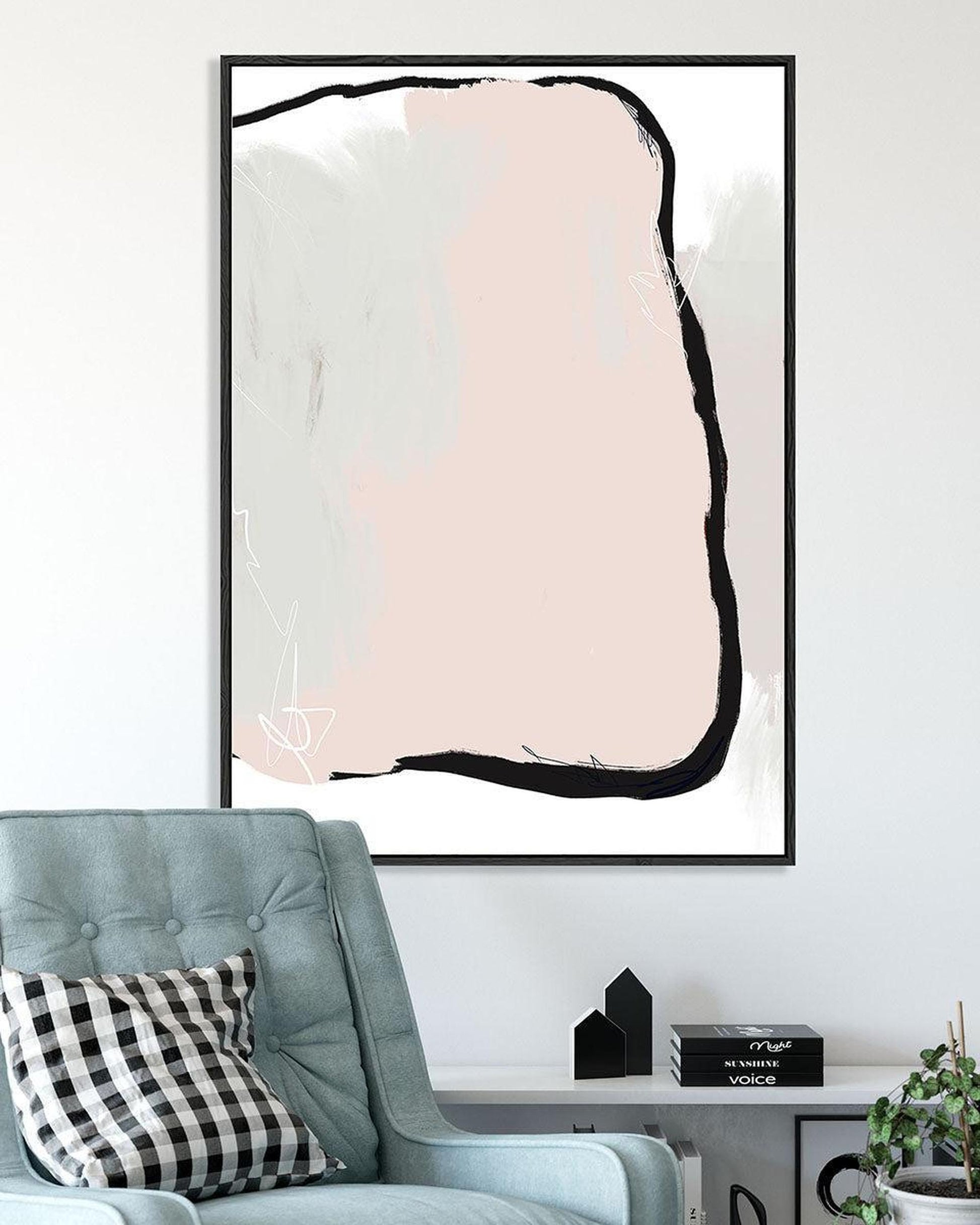 Abstract art print with a pink and black design on a white wall above a light blue armchair.
