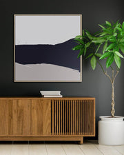 Modern interior with abstract art, wooden cabinet, and potted plant against a dark wall.