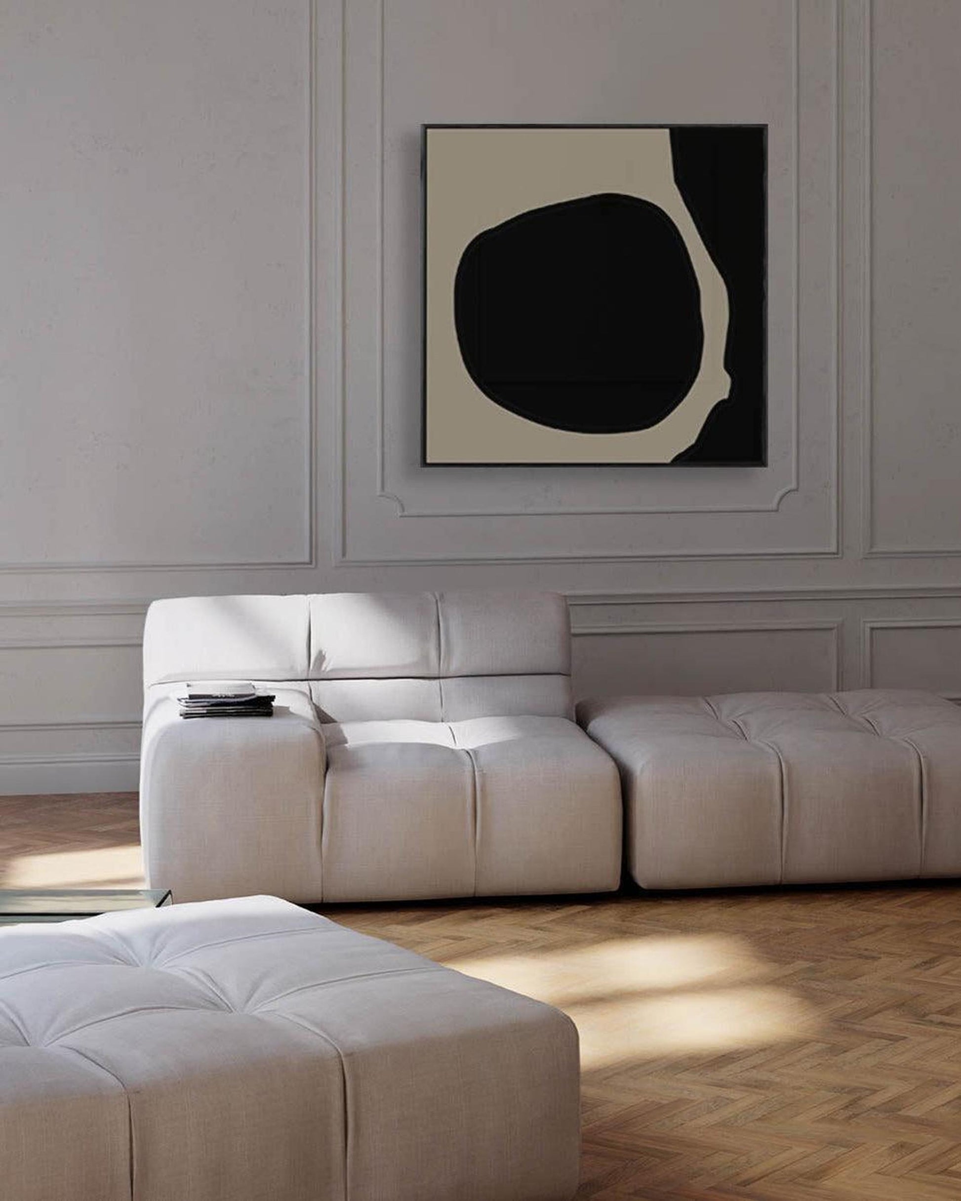 Modern living room with a white sofa and abstract art on the wall.