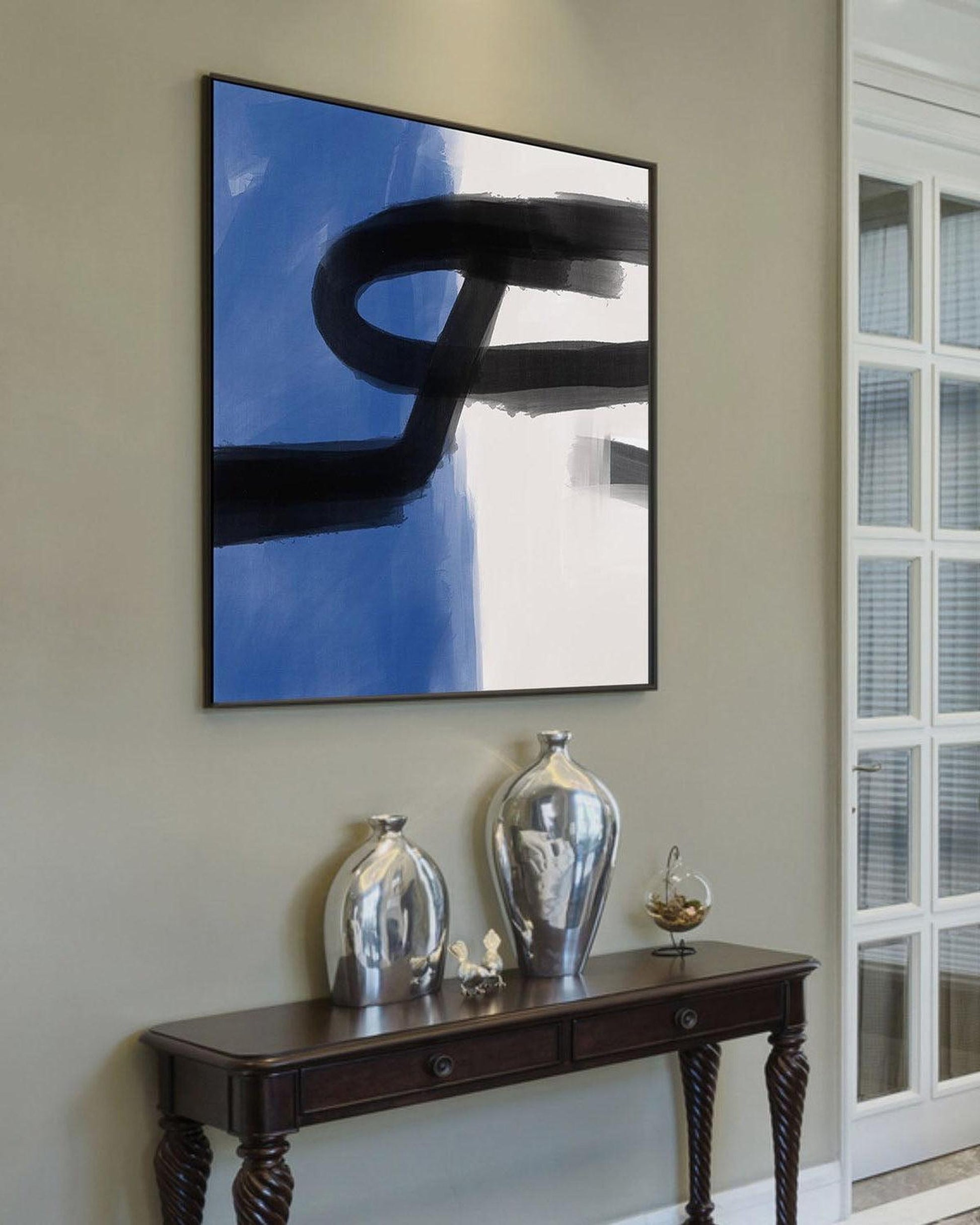 Modern interior with abstract art on the wall and decorative vases on a console table.