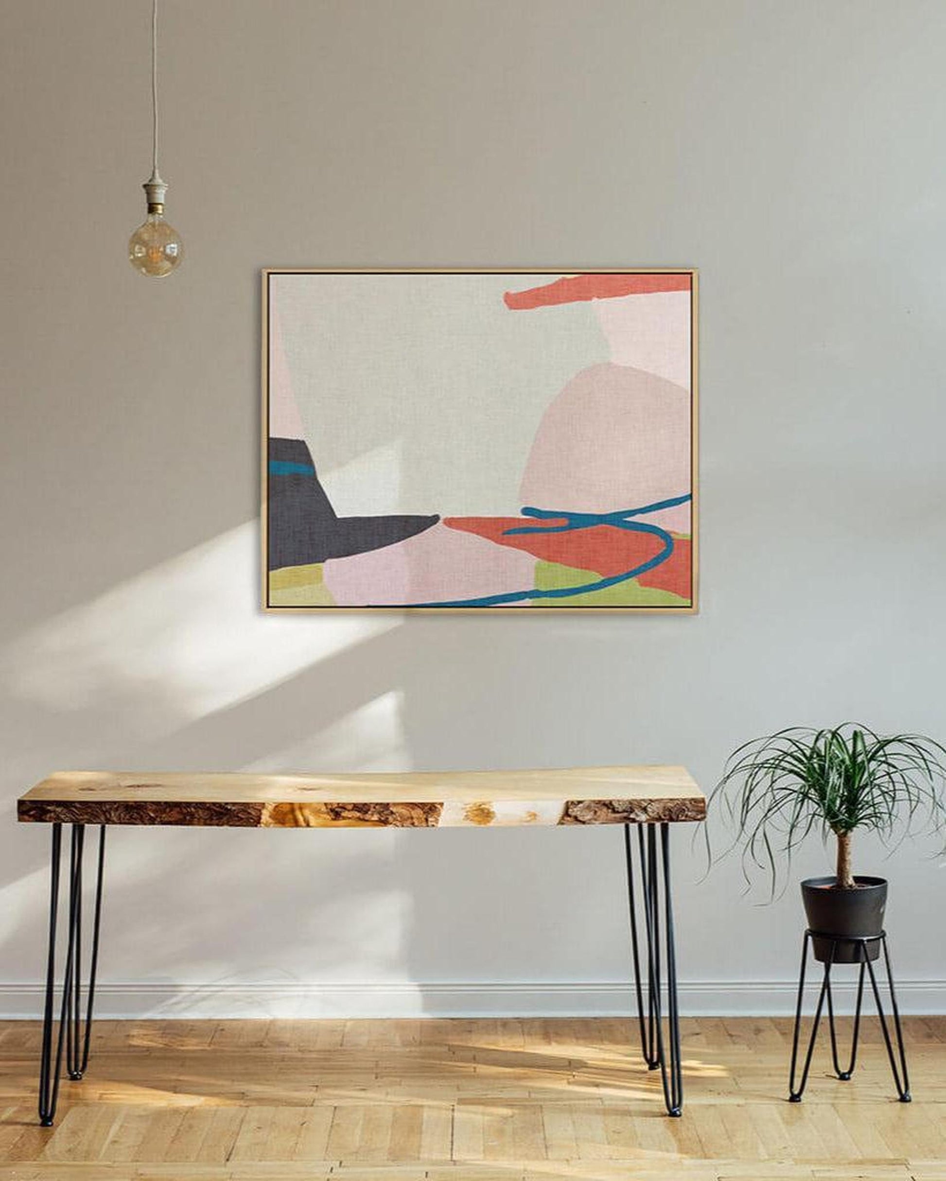 Modern interior with a wooden bench, abstract art, and a plant.