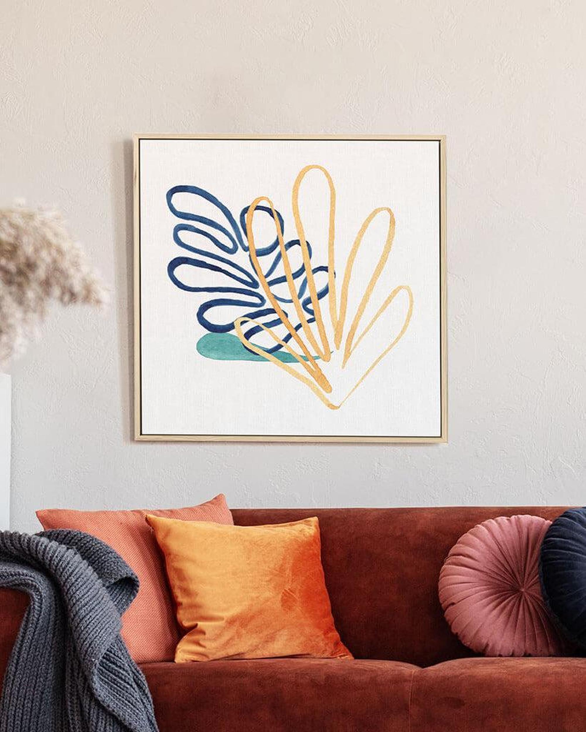 A framed canvas print featuring abstract botanical art in a vibrant color palette, displayed above a brown sofa with orange and pink cushions.