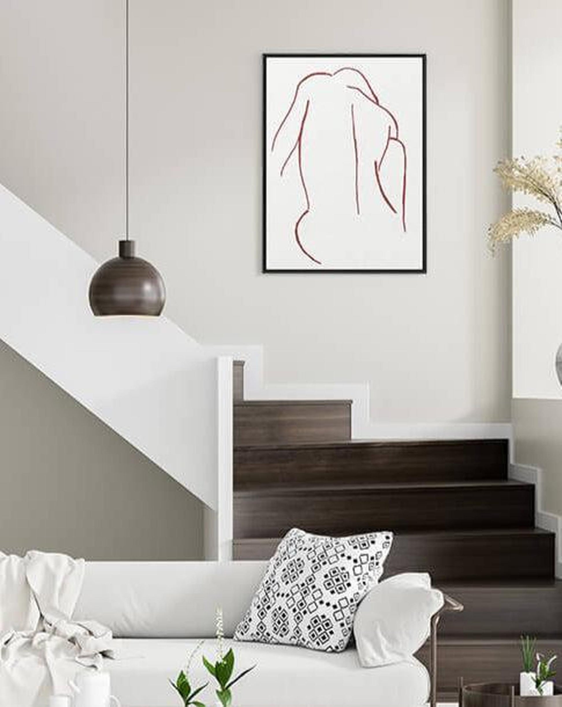 Modern living room with a white sofa, decorative pillows, and a framed abstract artwork on the wall.