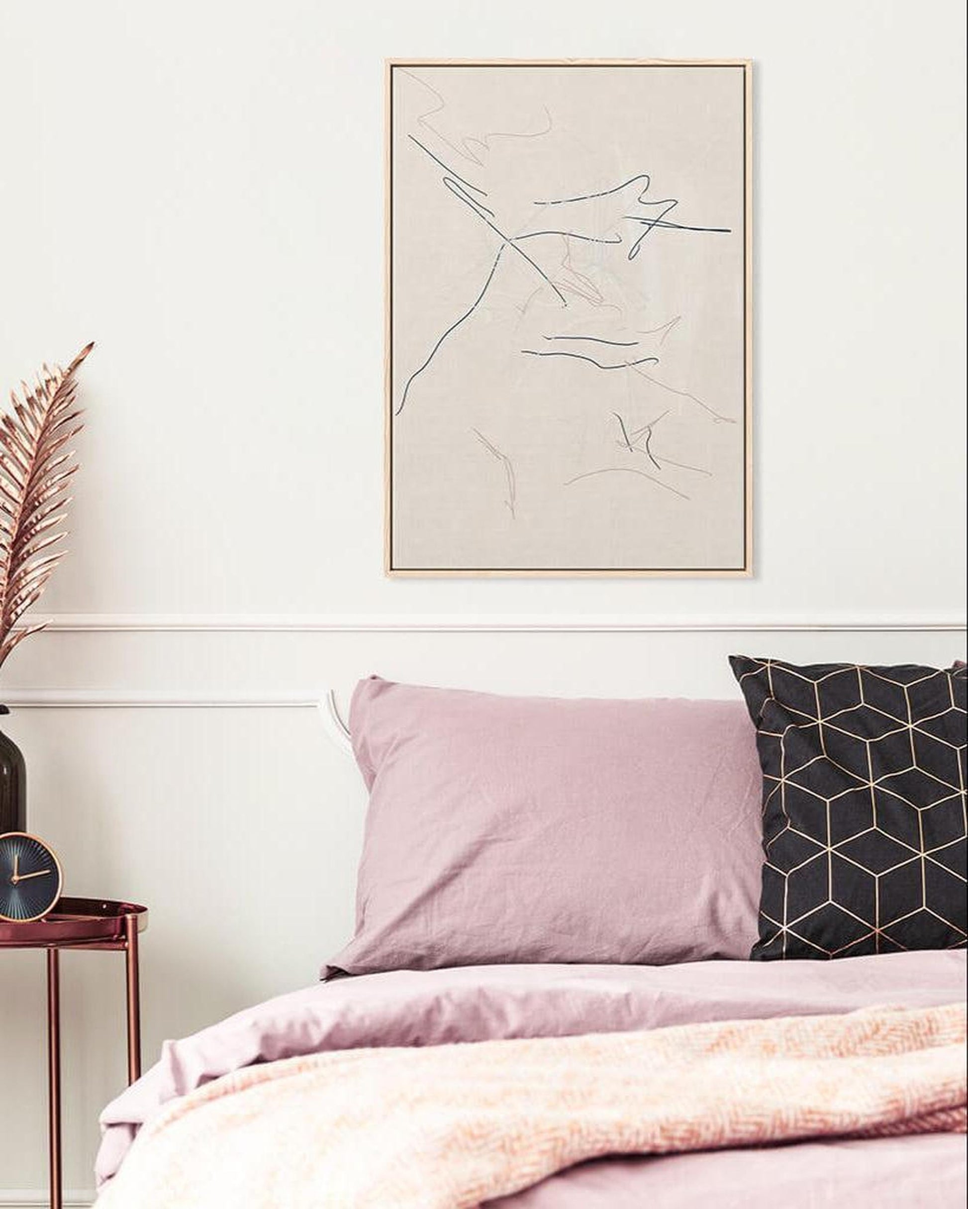 Bedroom with pink bedding, black geometric pillow, and abstract art on the wall.