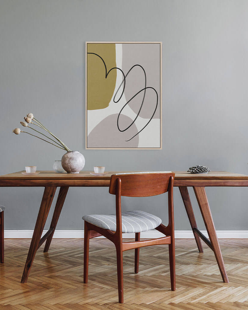 Dining room with wooden table and chairs, abstract art on the wall.