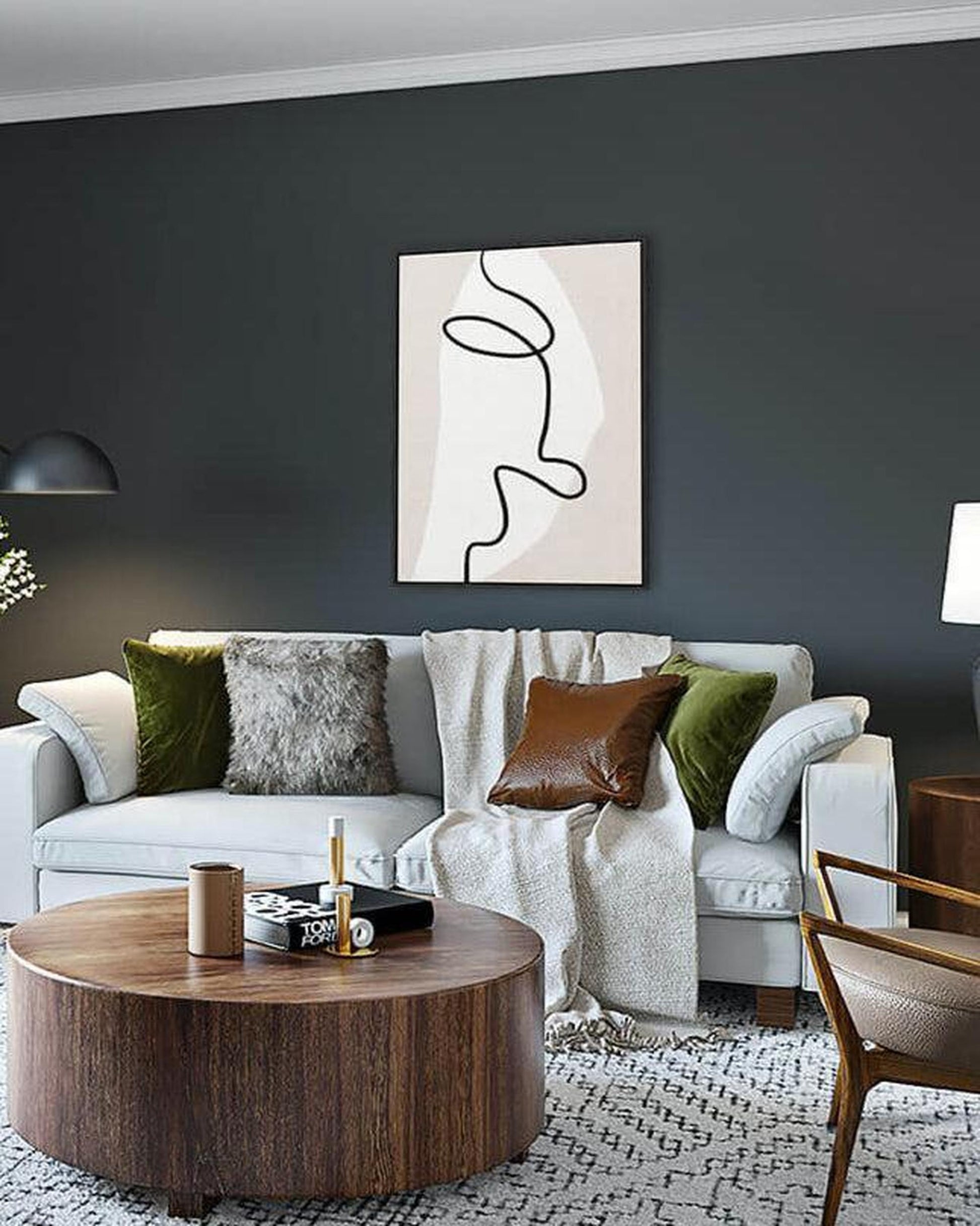 Modern living room with a gray sofa, wooden coffee table, and abstract art on the wall.