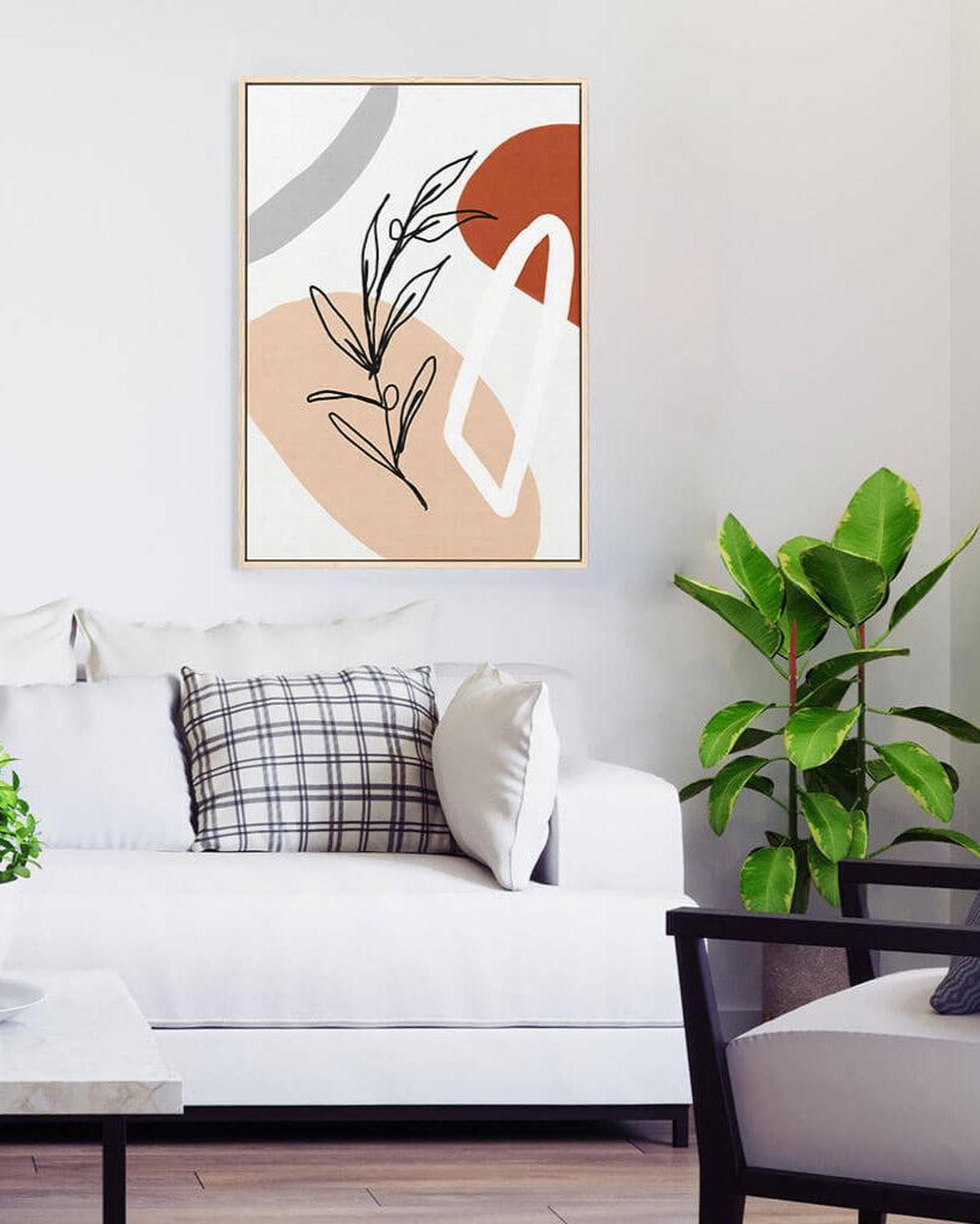 Modern living room with abstract art on the wall, white sofa, and plants.
