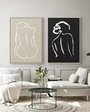 Two abstract art pieces of nude figures on a wall in a living room.