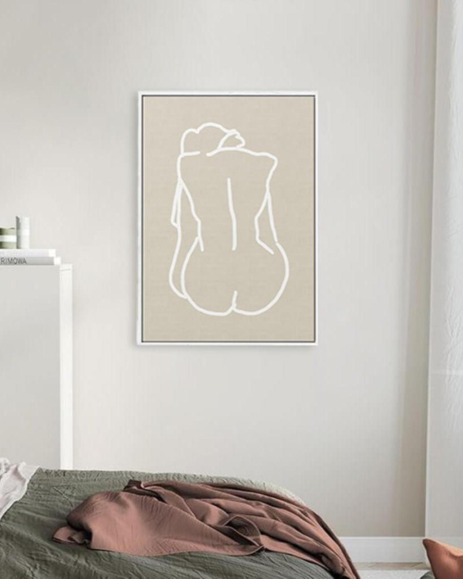 Minimalist line art of a nude figure on a beige background in a modern bedroom.