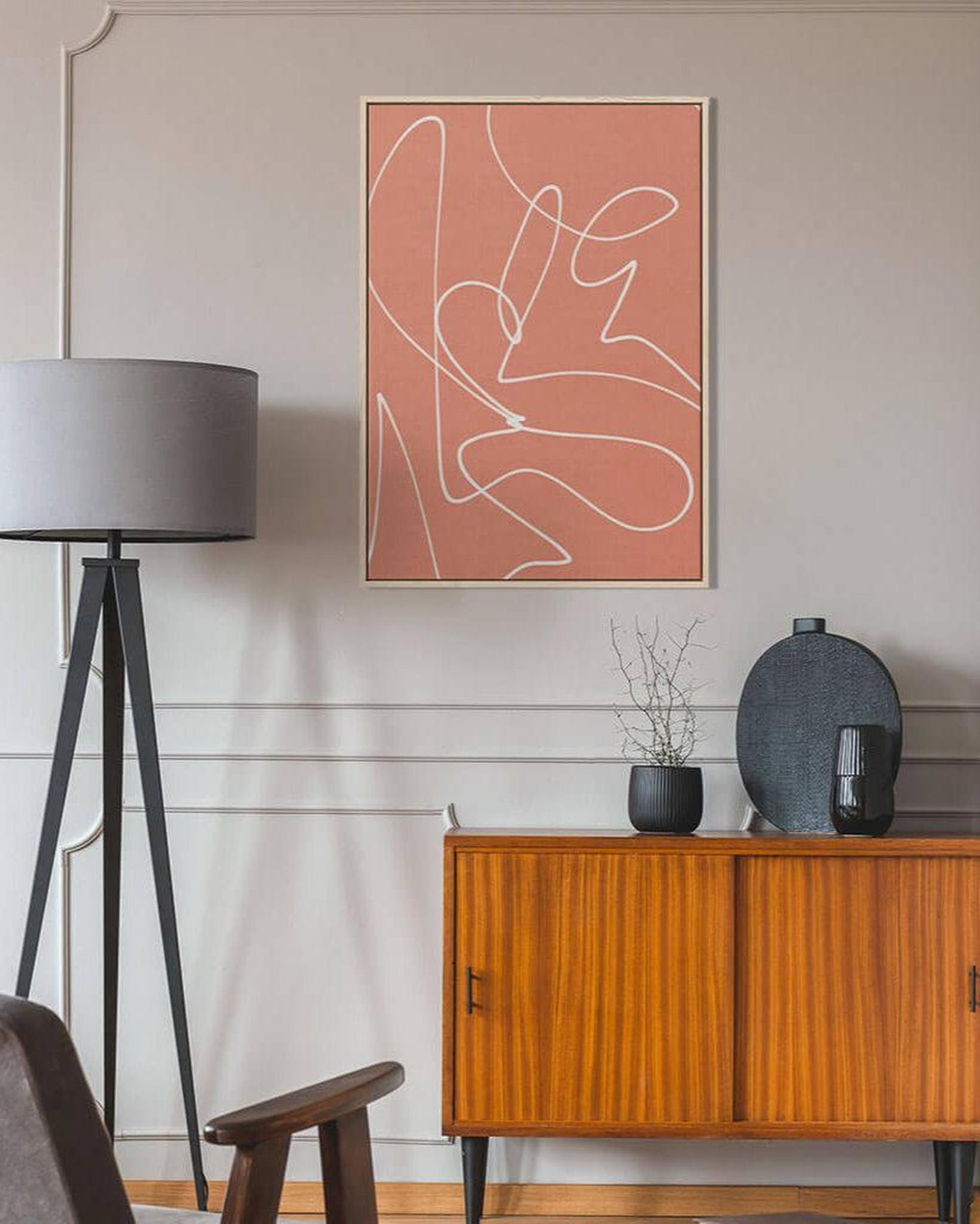 Modern interior with abstract art, wooden cabinet, and floor lamp.
