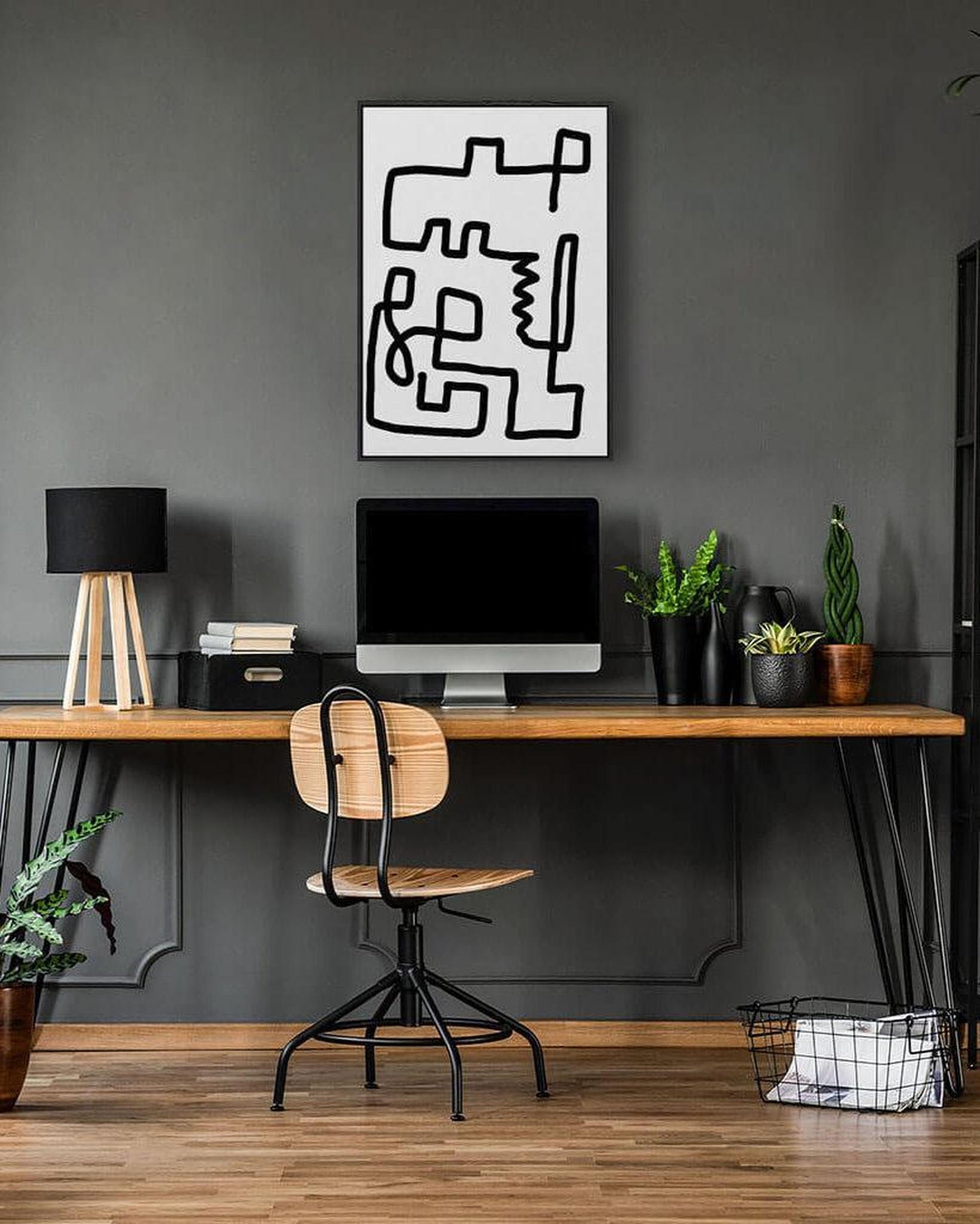 Modern home office with a wooden desk, chair, and abstract wall art.