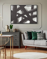 Living room with abstract art on the wall, gray sofa, and wooden floor.