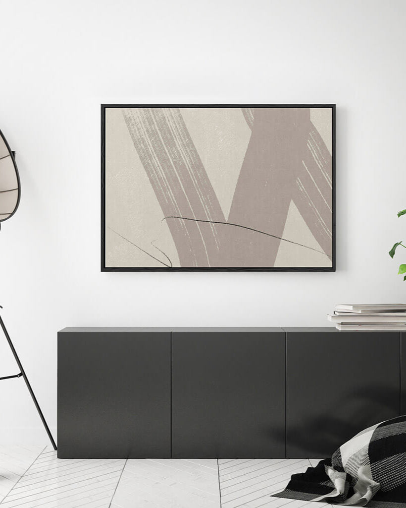 Abstract art piece on a white wall above a black cabinet
