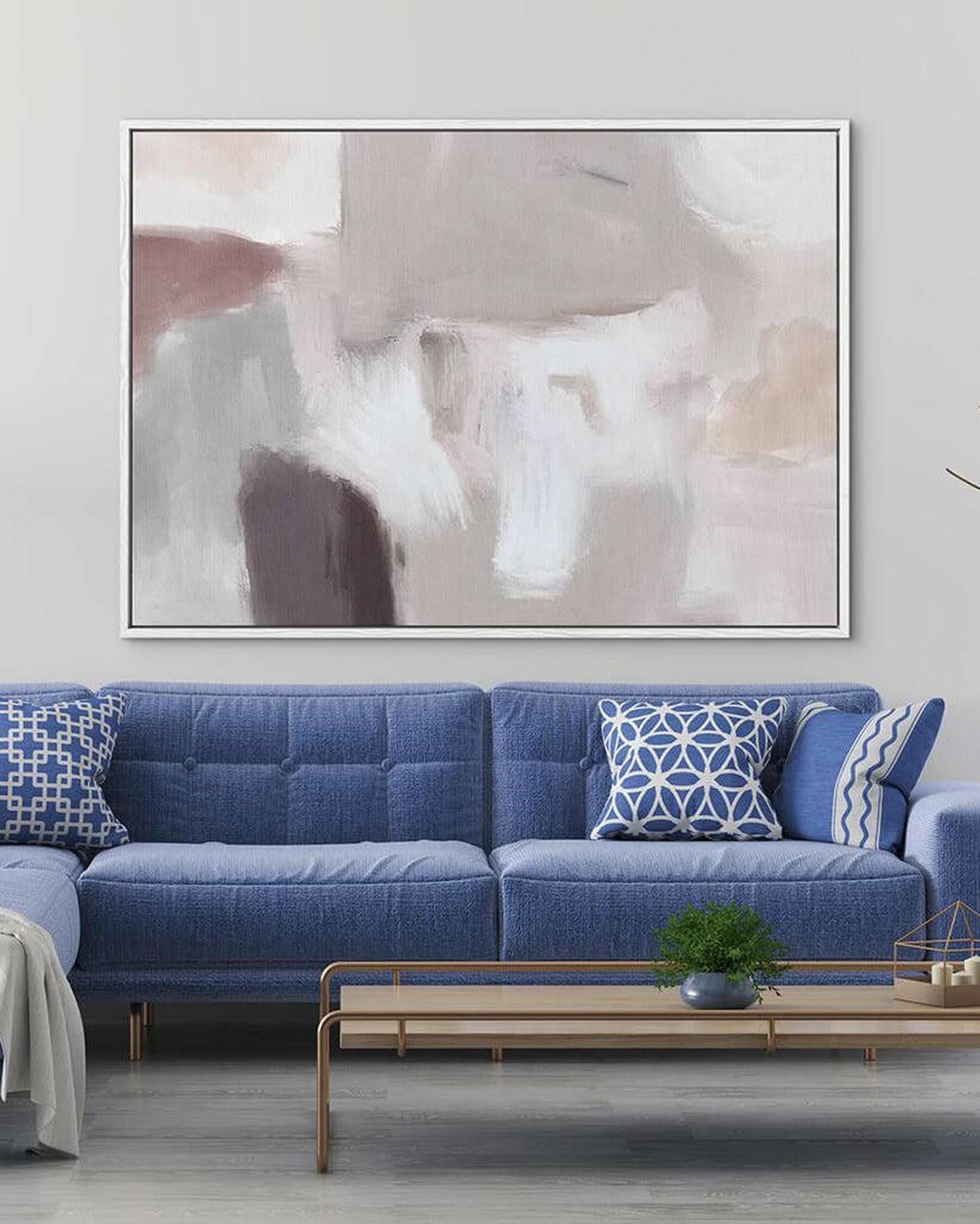 Living room with a blue sofa, abstract art on the wall, and a coffee table.