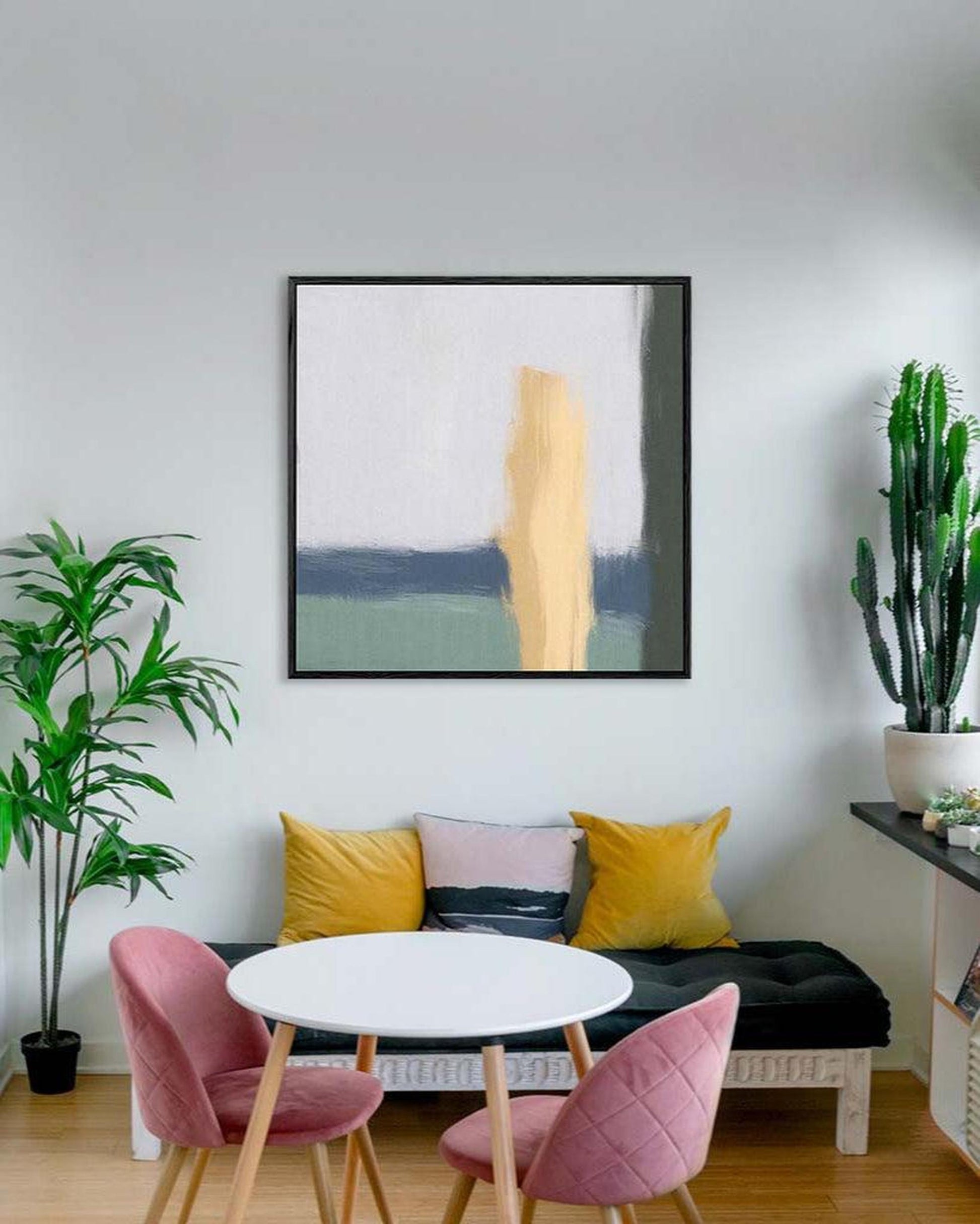 Modern living room with abstract art, pink chairs, and a round table.
