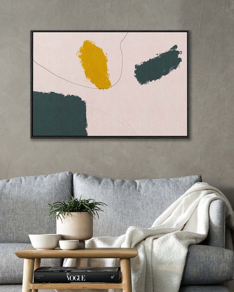 Abstract art print on a wall above a sofa with a coffee table.