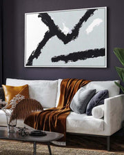 Modern living room with a white sofa, abstract art, and decorative pillows.