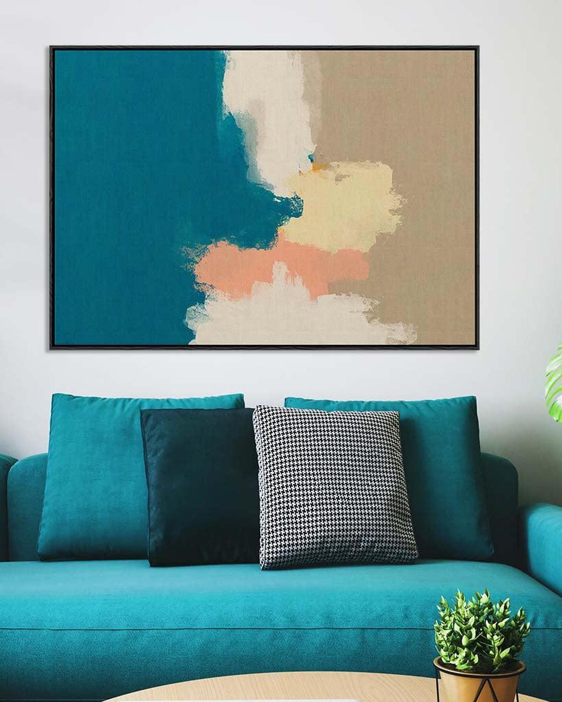 Teal sofa with decorative pillows and a colorful abstract painting on the wall.