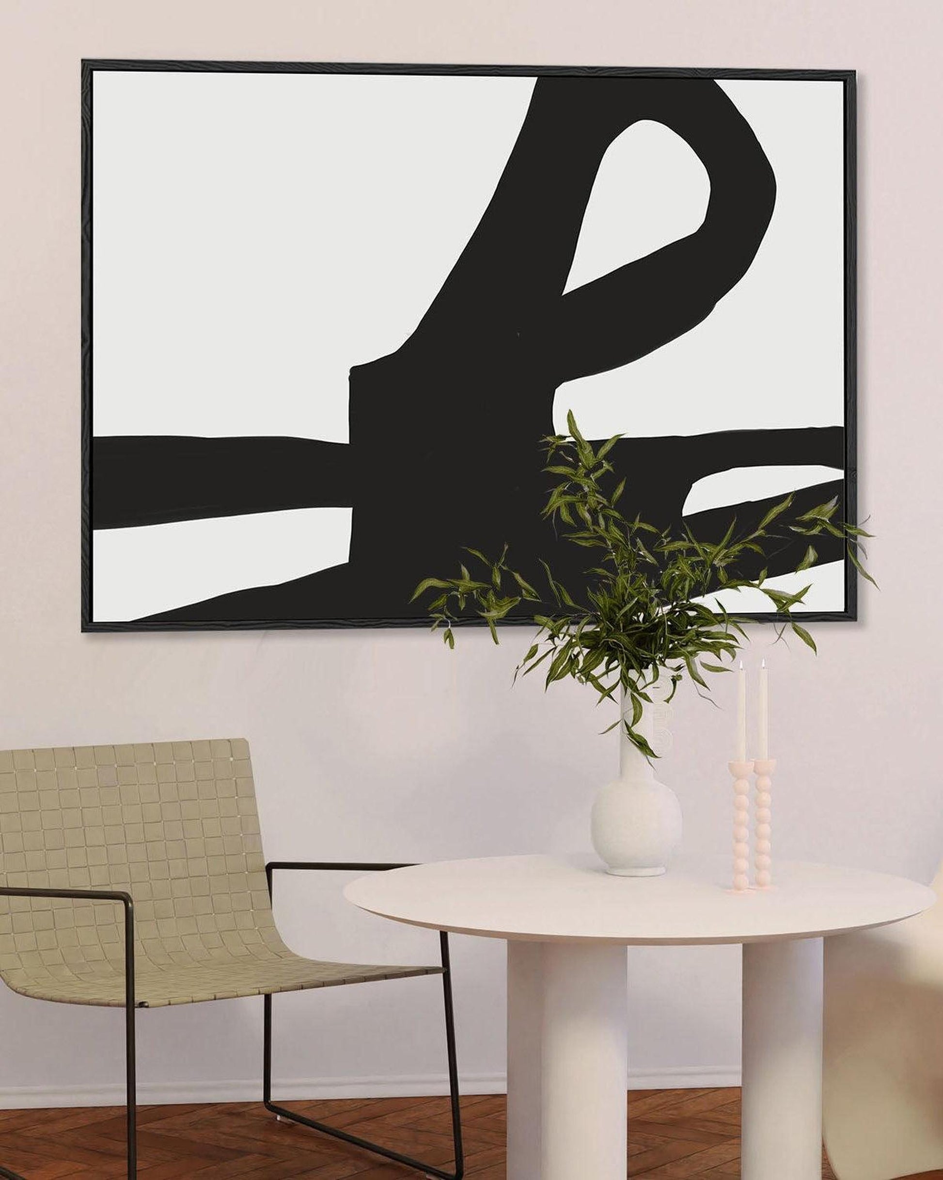 Modern interior with abstract black and white artwork, green chair, and white table.