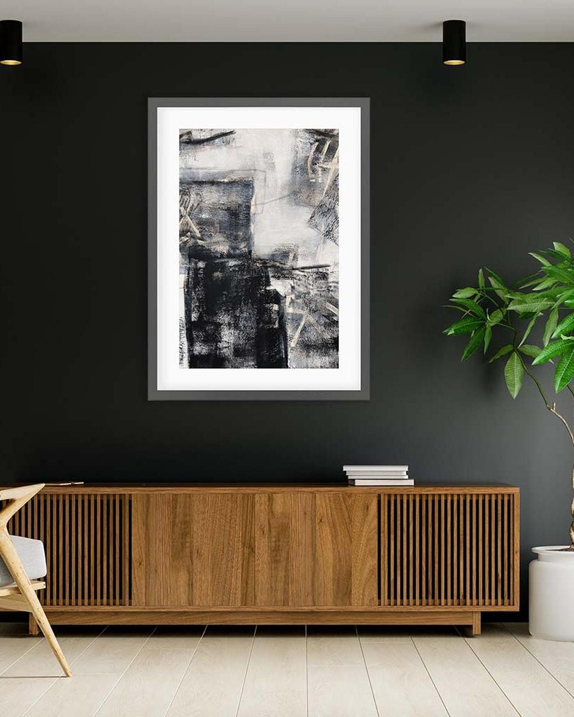 Framed abstract art on a dark wall above a wooden console table.