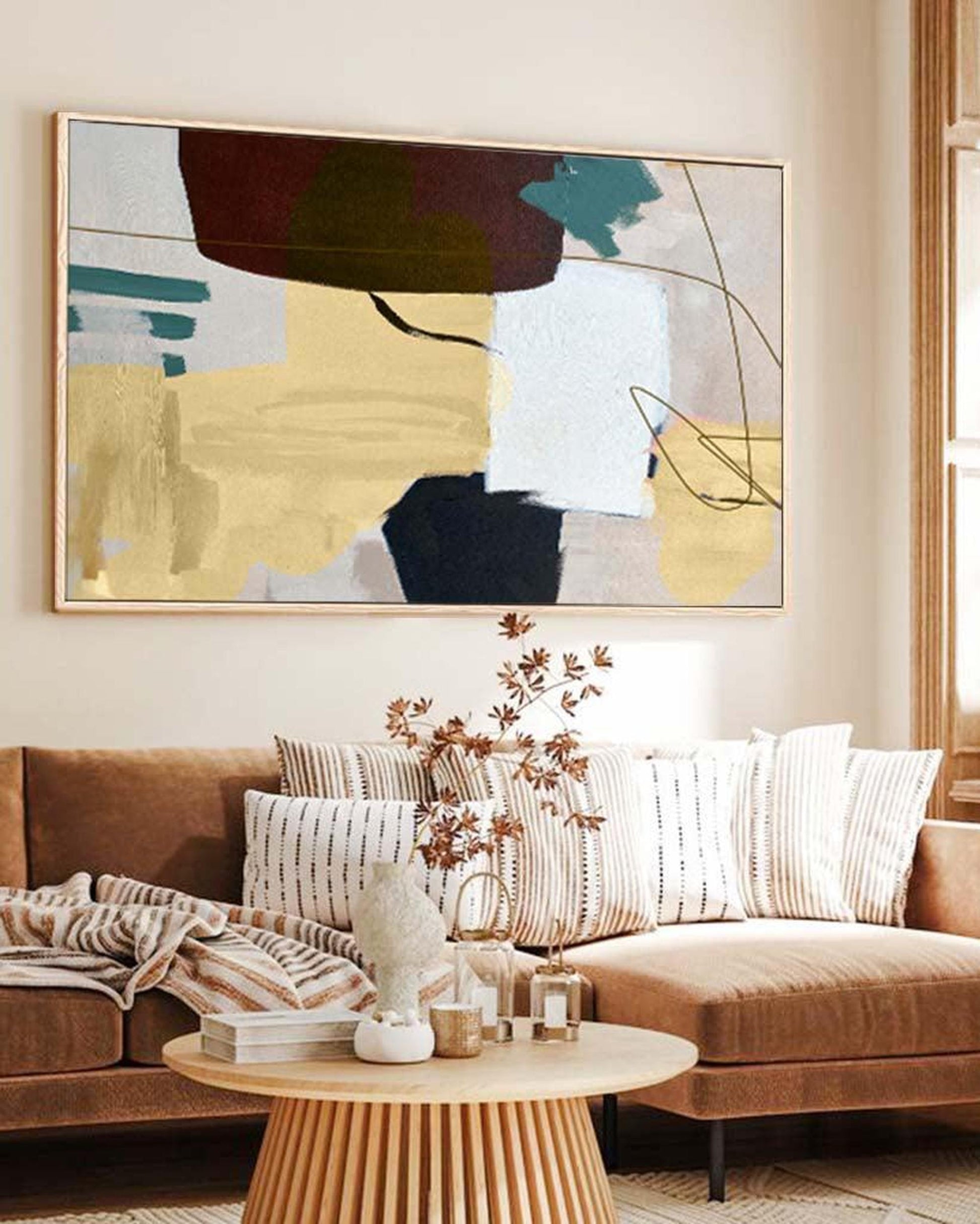 Living room with a brown sectional sofa, abstract art on the wall, and a wooden coffee table.