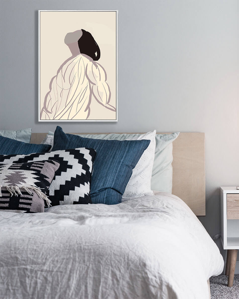 Bedroom with a bed featuring blue and patterned pillows, a blanket, and a framed artwork on the wall.