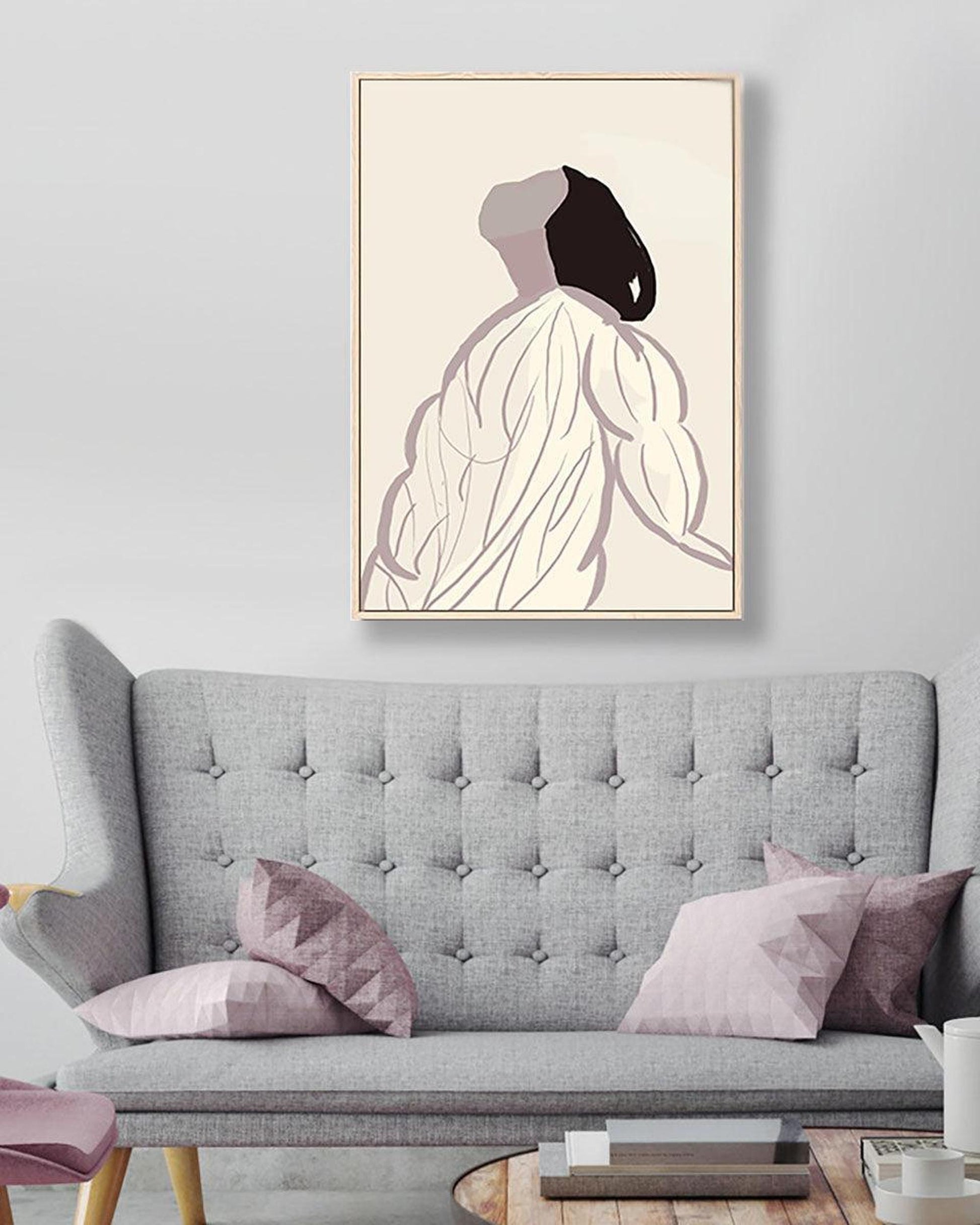 Gray sofa with pink cushions and a framed abstract art piece on the wall.