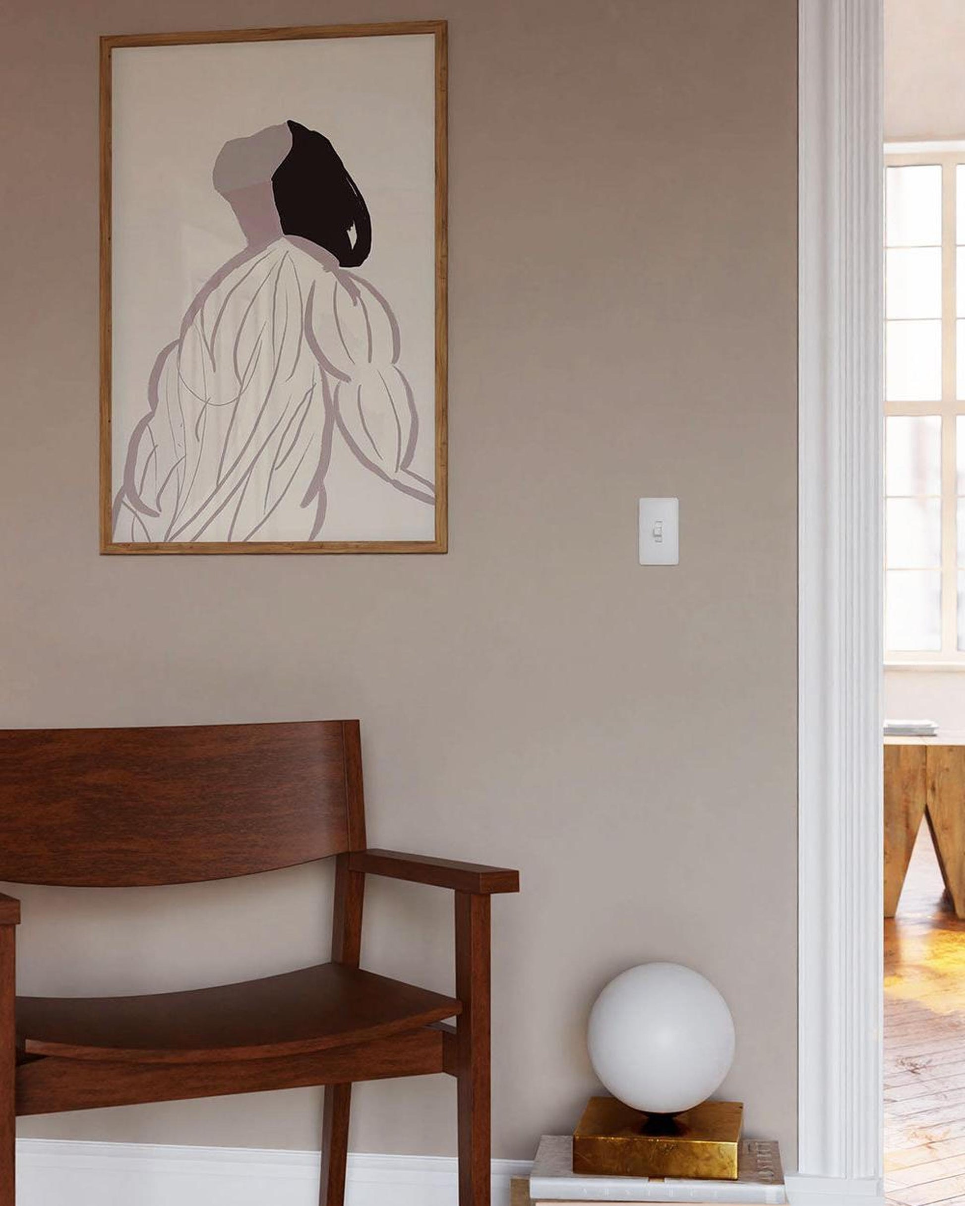 Framed abstract art on a wall above a wooden bench in a room.