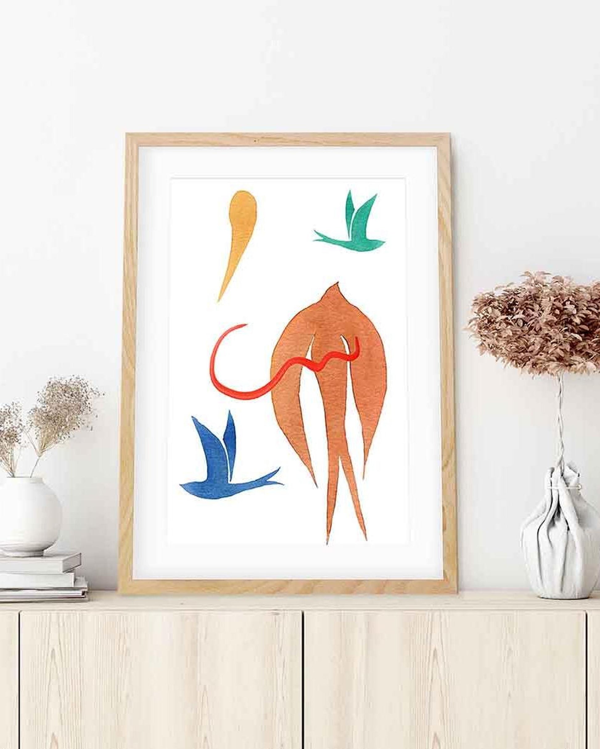 Framed abstract artwork with colorful shapes on a white wall.