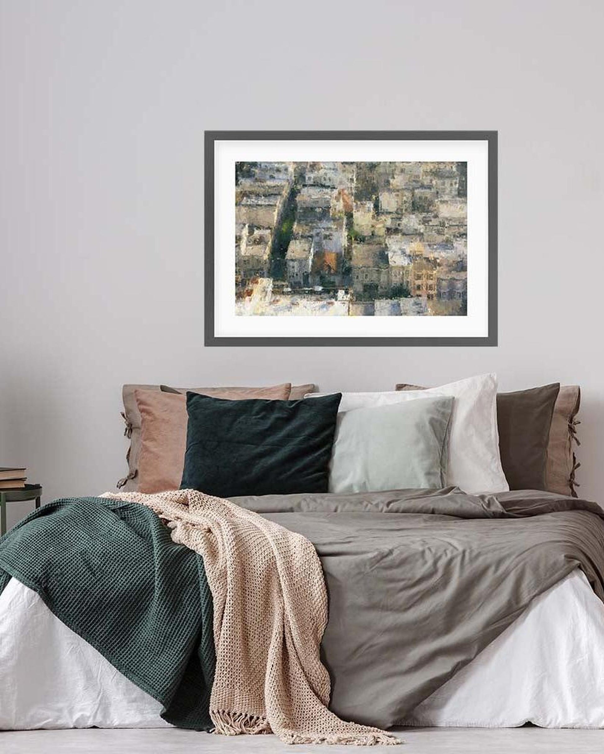 Framed artwork above a bed with colorful bedding