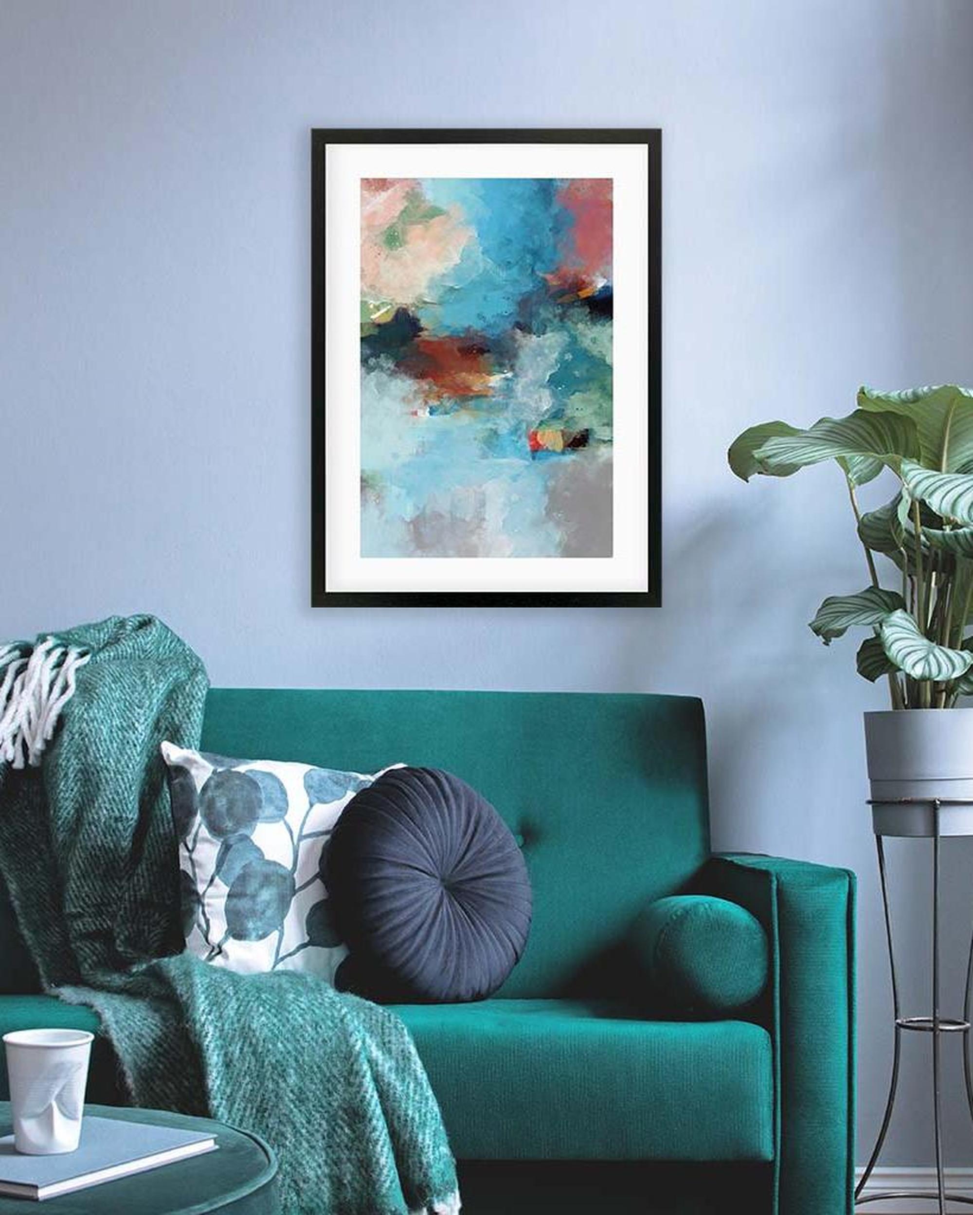 Green sofa with decorative pillows and a plant in a modern living room.