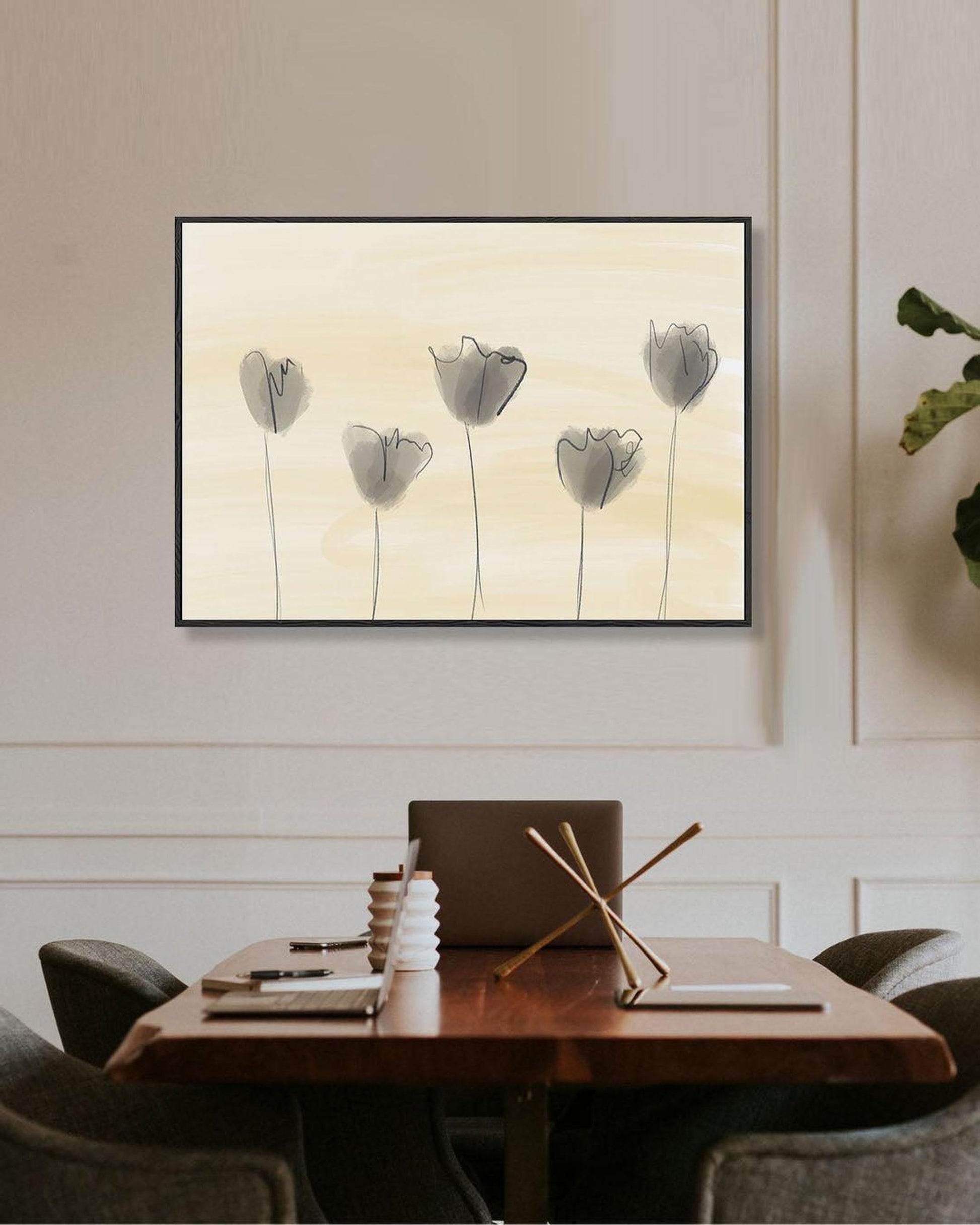 Framed artwork of tulips on a wall above a dining table.
