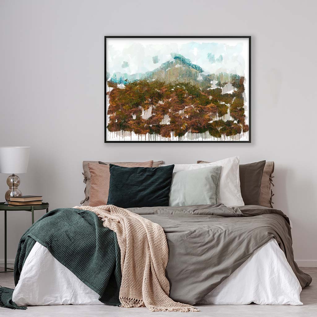 framed landscape artwork hung above a bed