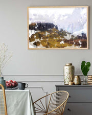 Framed abstract art piece on a wall above a table with decorative items.