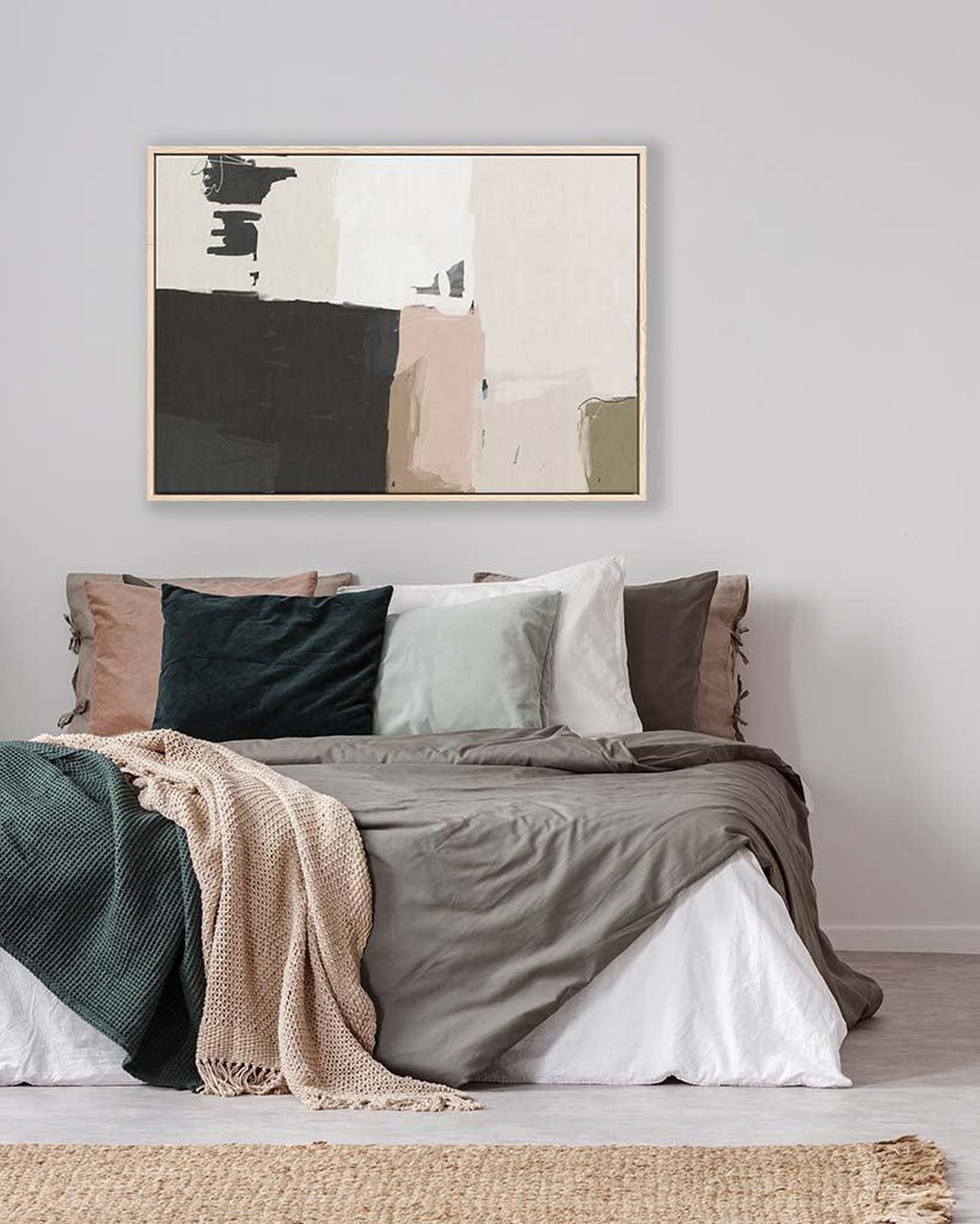 Bedroom with abstract art on the wall and layered bedding.